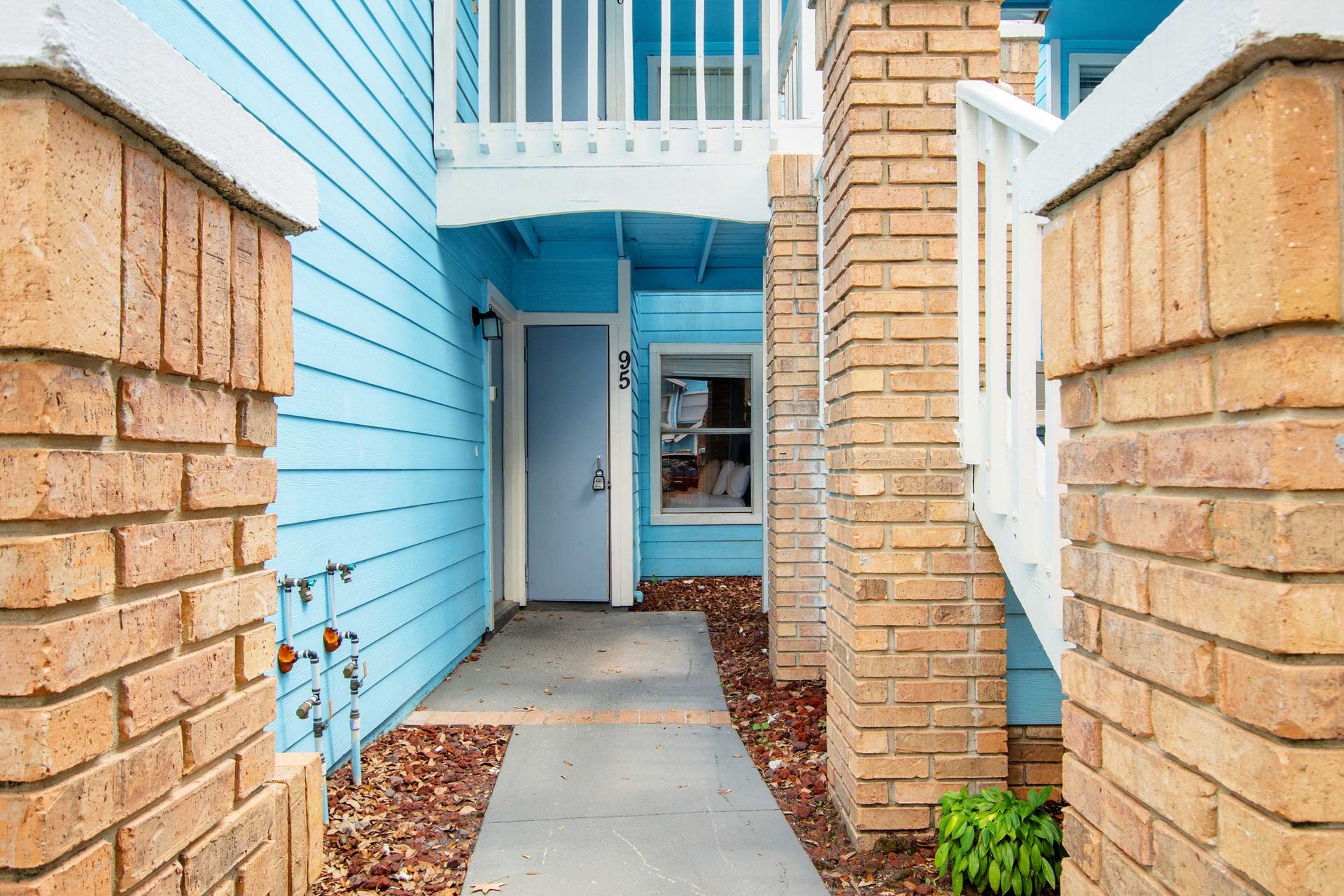 Private ground-floor entry welcomes you with a cheerful blue facade.