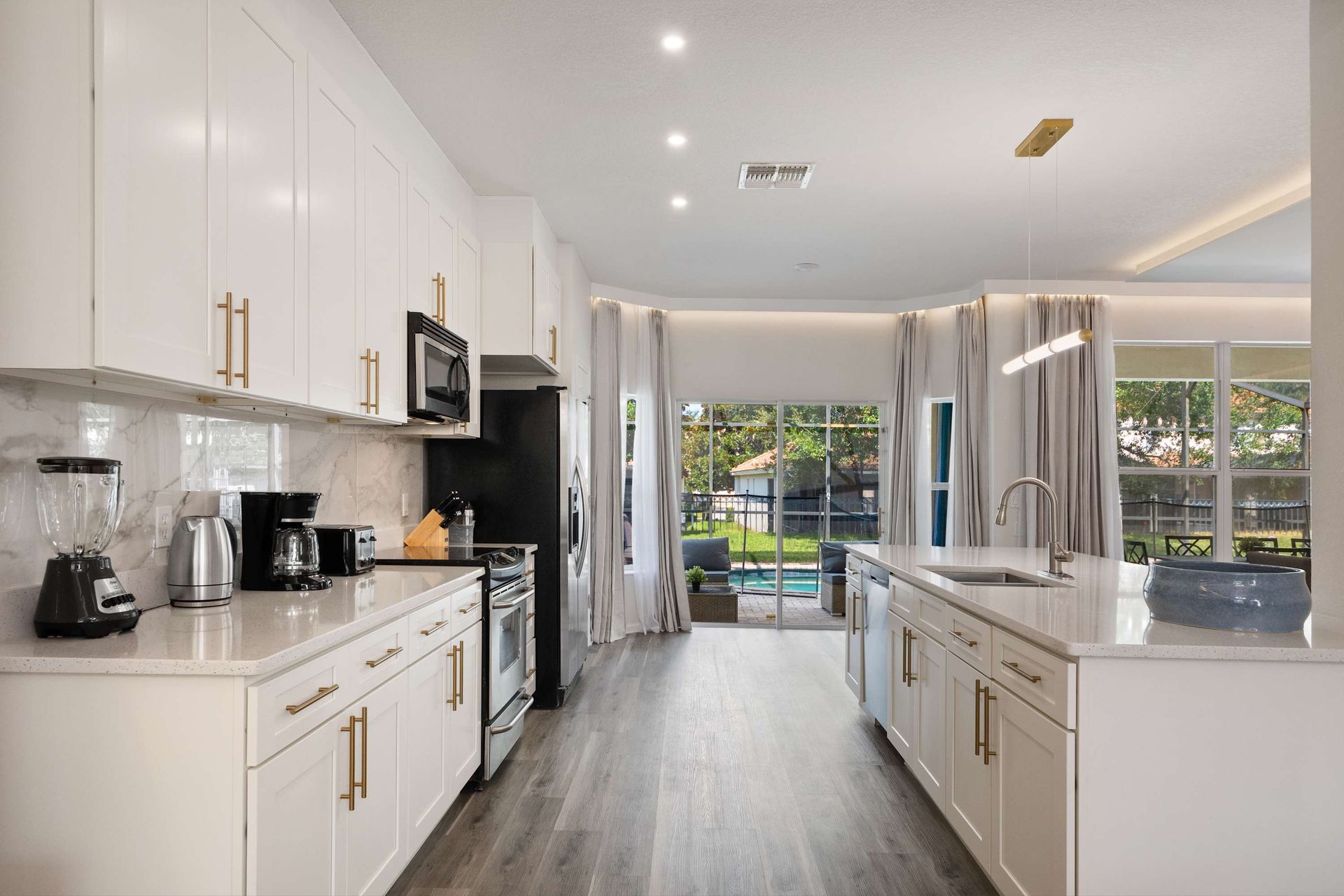 Bright, modern kitchen fully equipped and overlooking the pool.