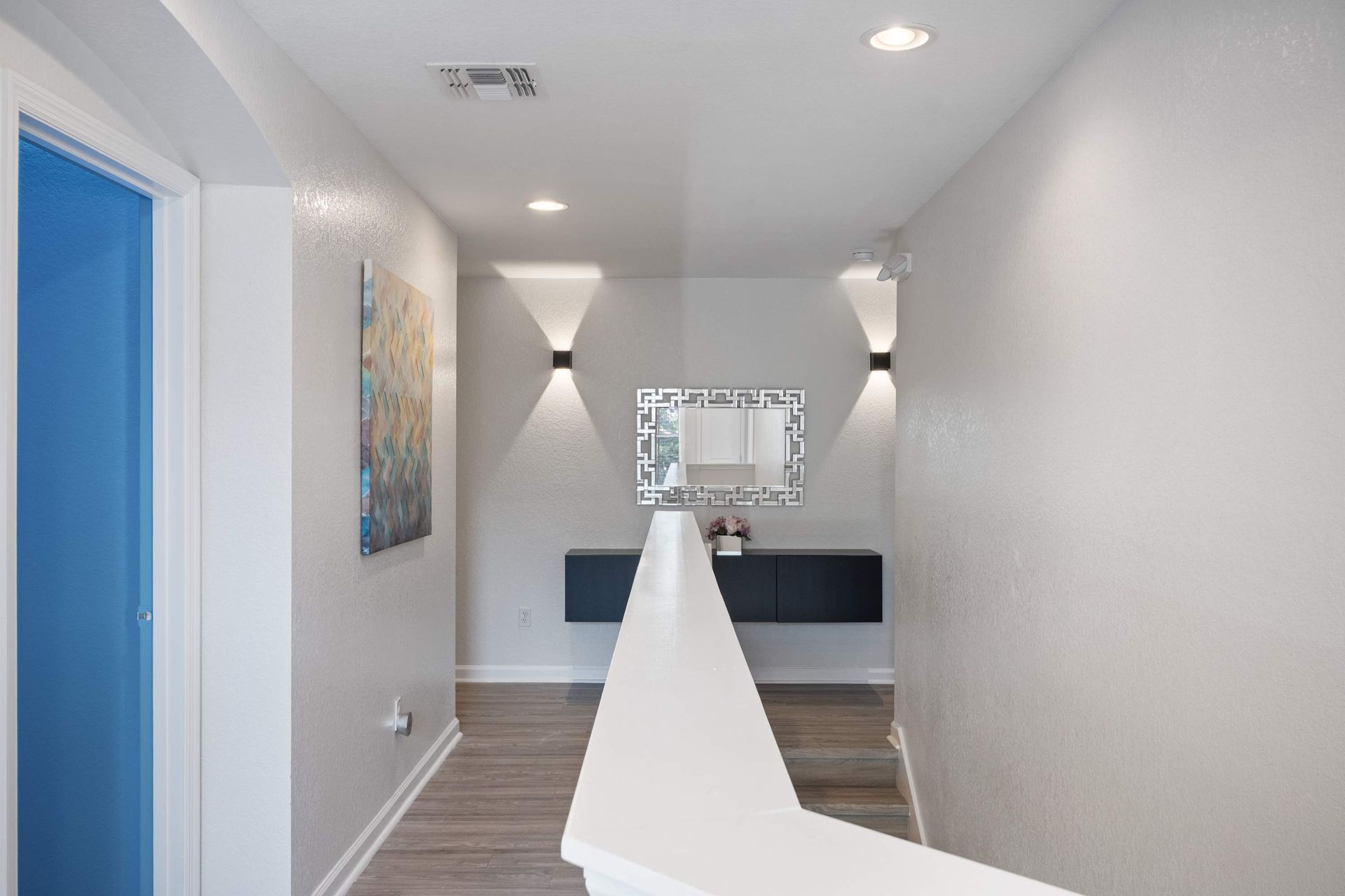 Chic landing with wall art and unique accent lighting.