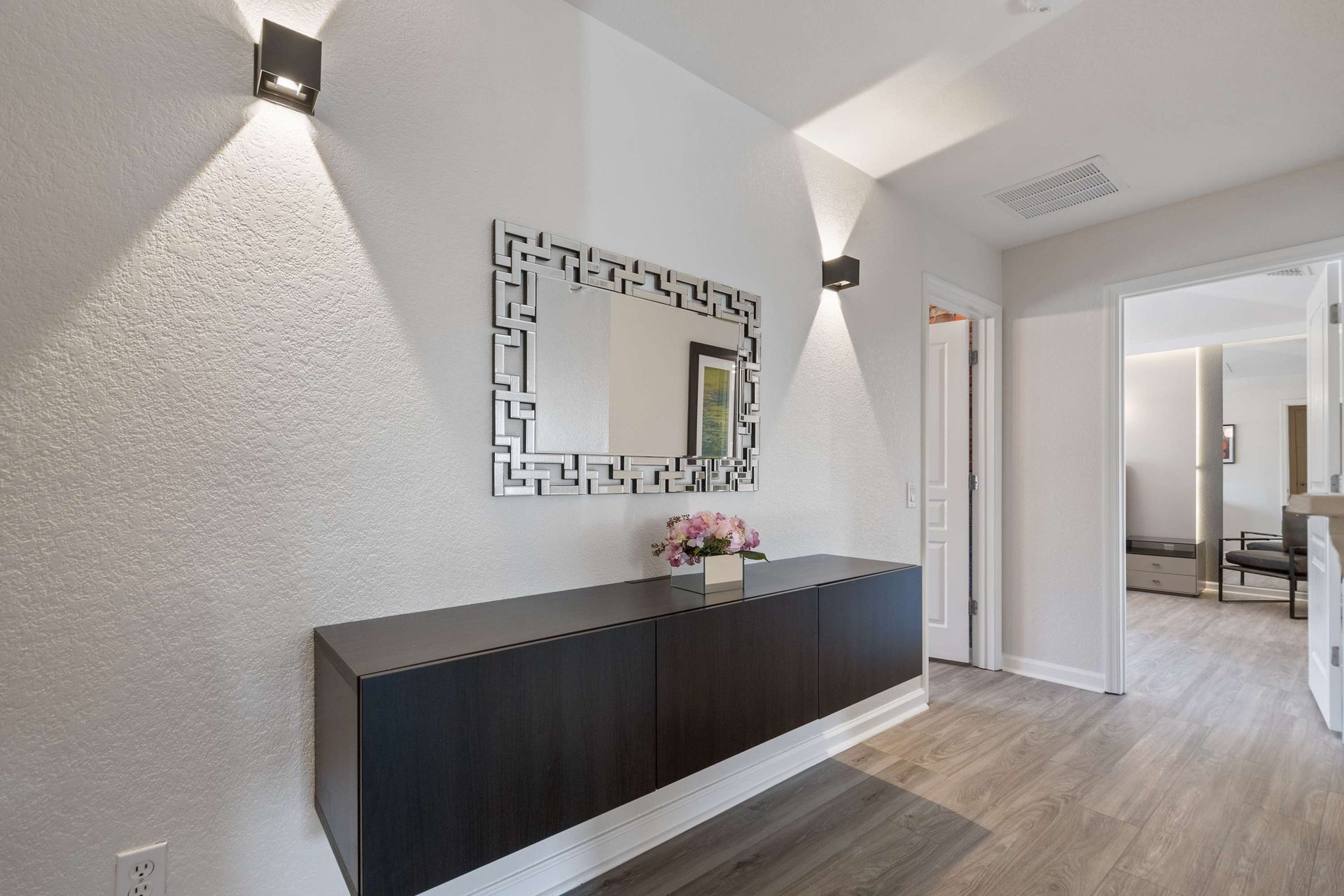 Stylish hallway with dramatic sconce lighting and minimalist decor.