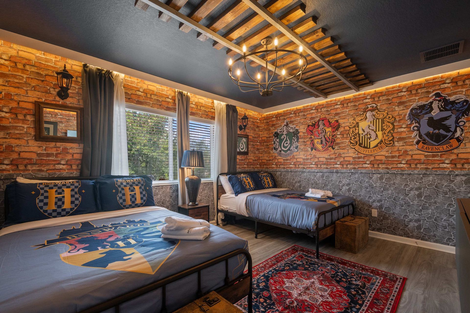 Hogwarts inspired theme room with two beds and house crests.