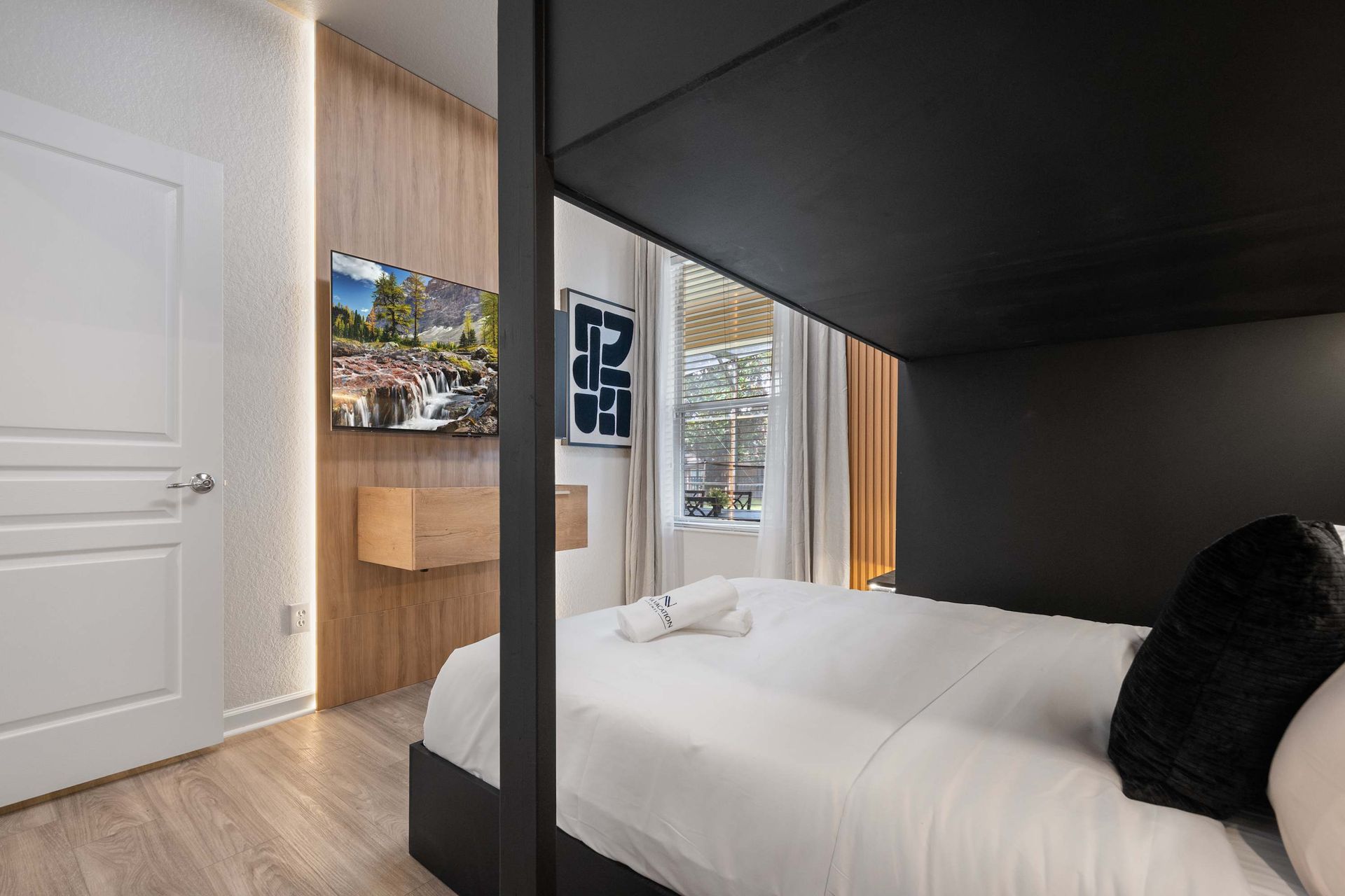 Modern bunk room with wood accents and a personal TV.