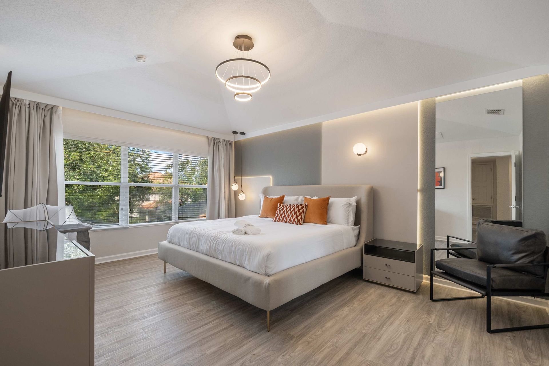 Modern elegance: chic velvet bed, stylish chair, and accent wall.