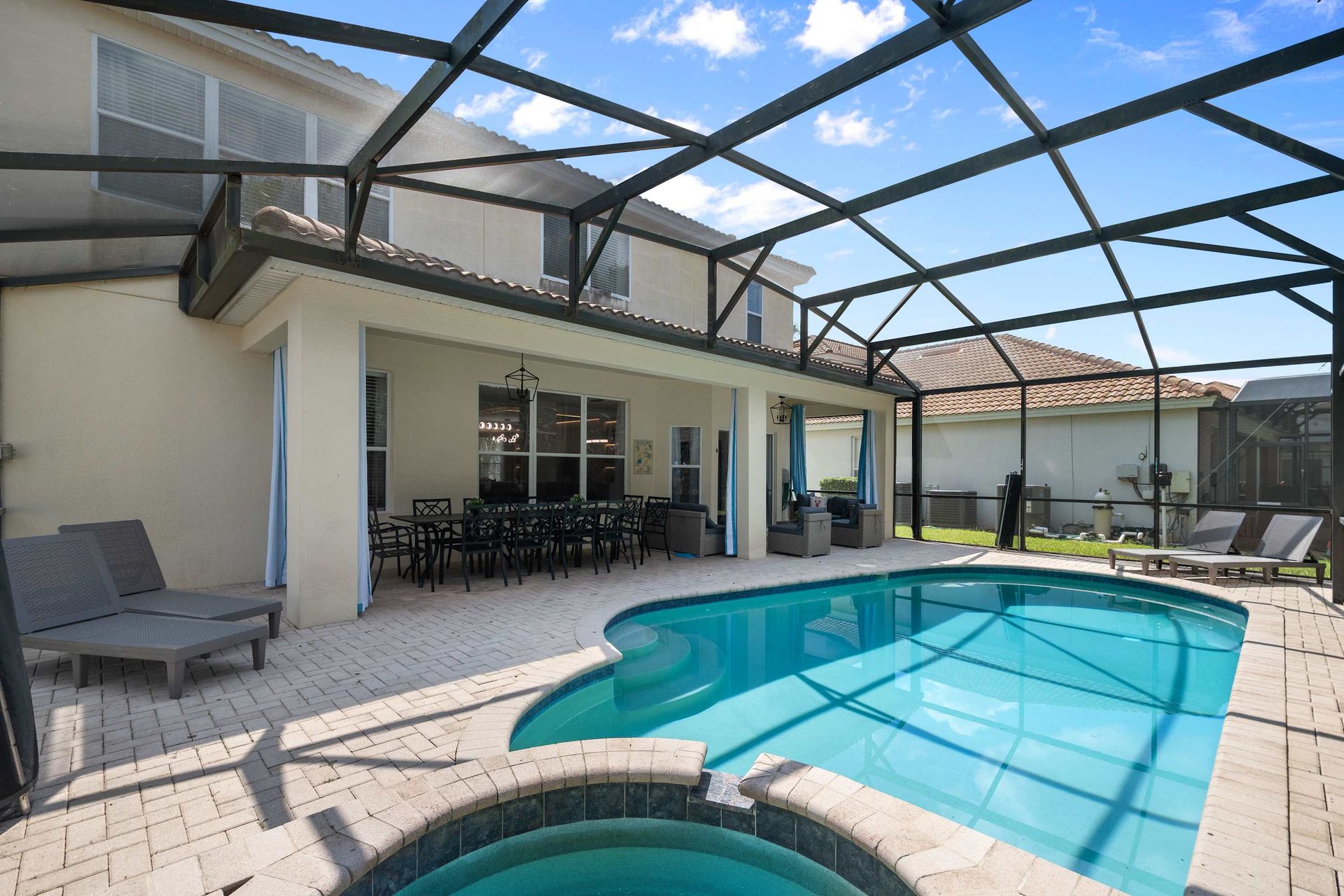 Large screened pool deck with loungers and covered seating.