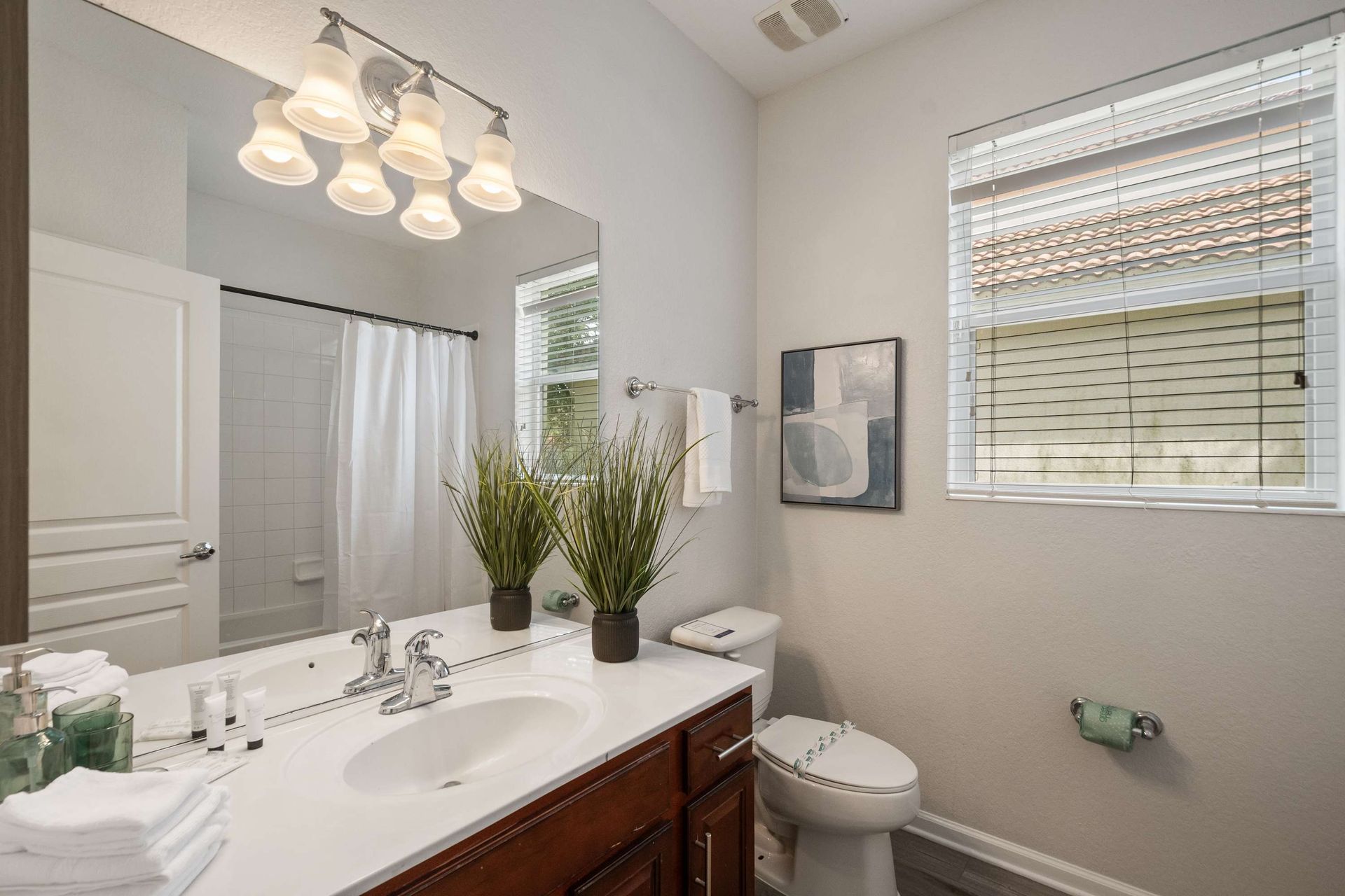 Full bathroom featuring a dark wood vanity and shower/tub combo.