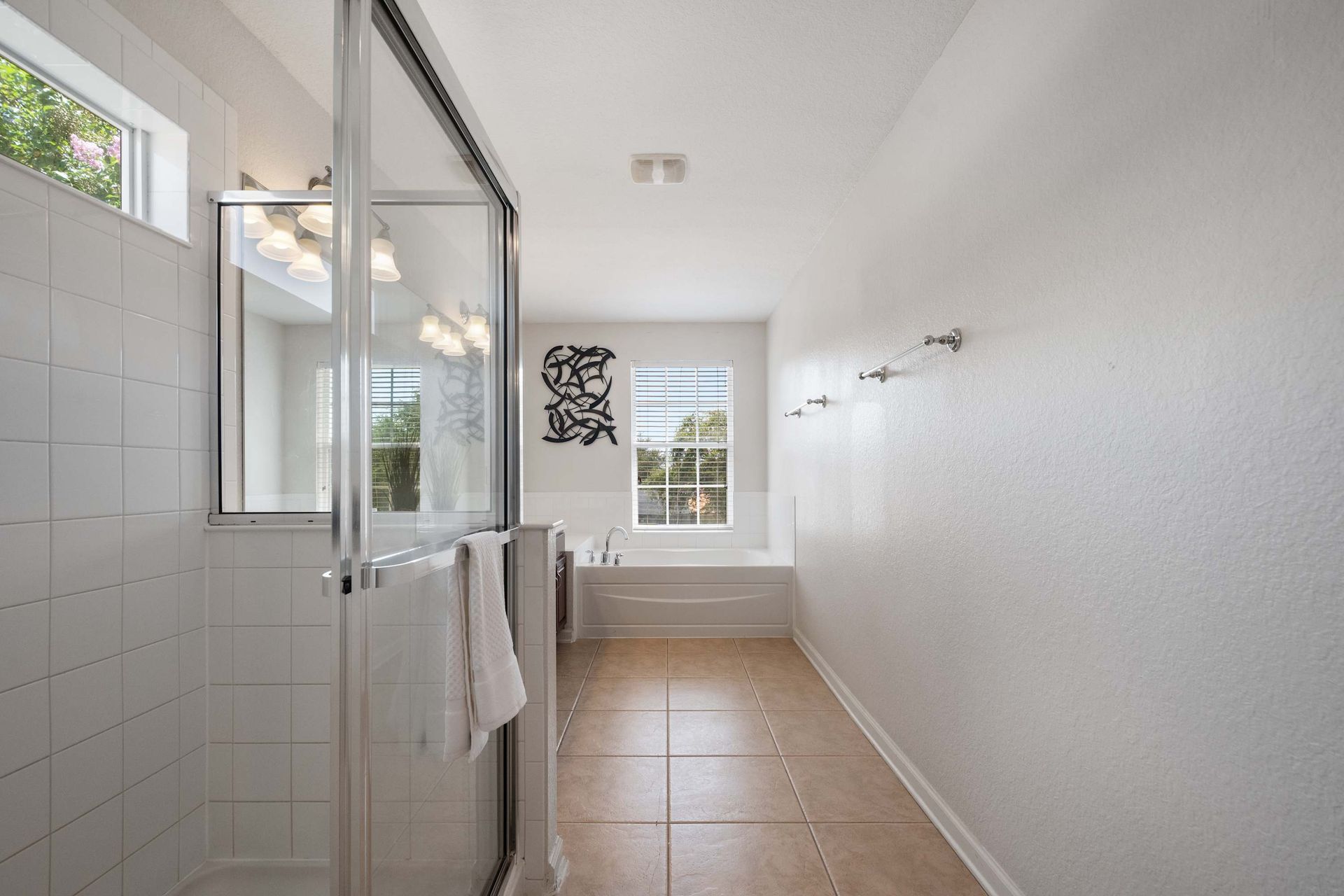 Bright and spacious bathroom with plenty of towel hooks and light. 