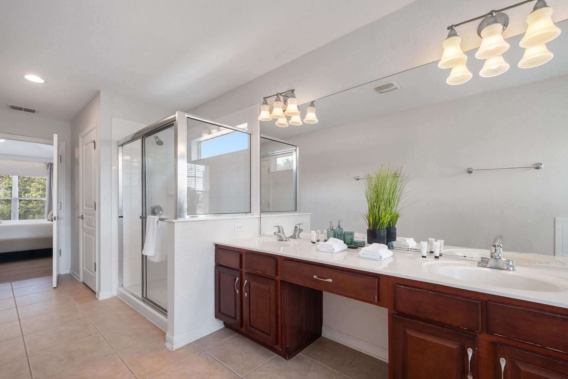 Clean and bright with rich wood cabinets and a huge mirror. 