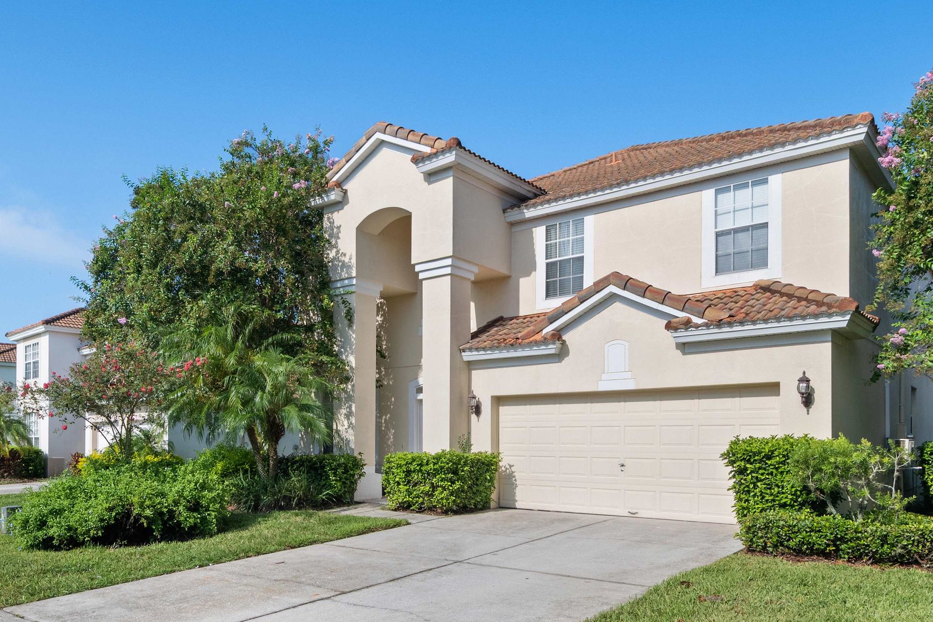 Beautiful two-story home with a tile roof and archway entrance. 