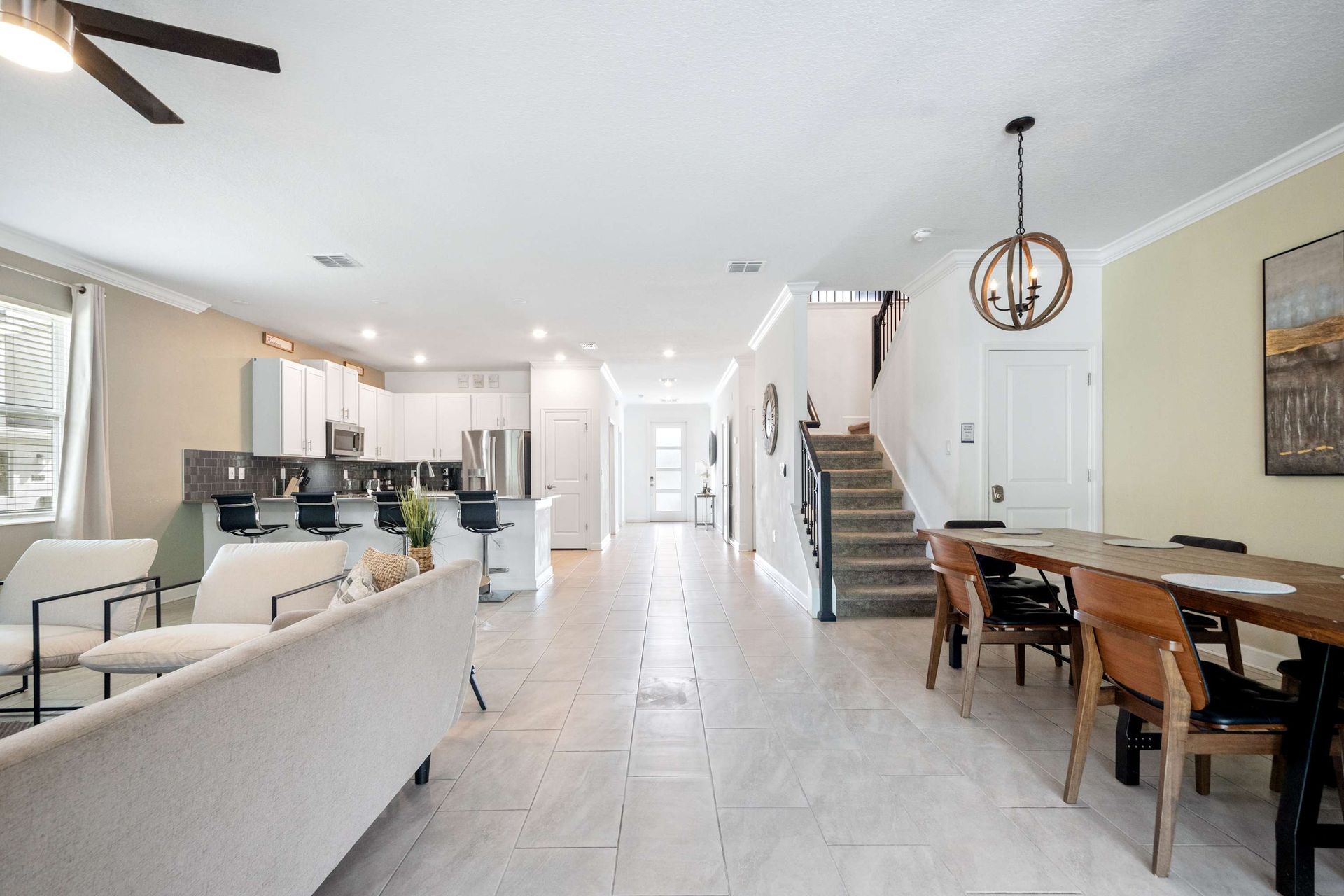 Open-plan living: lounge, dining, kitchen, and stairs in one bright space.