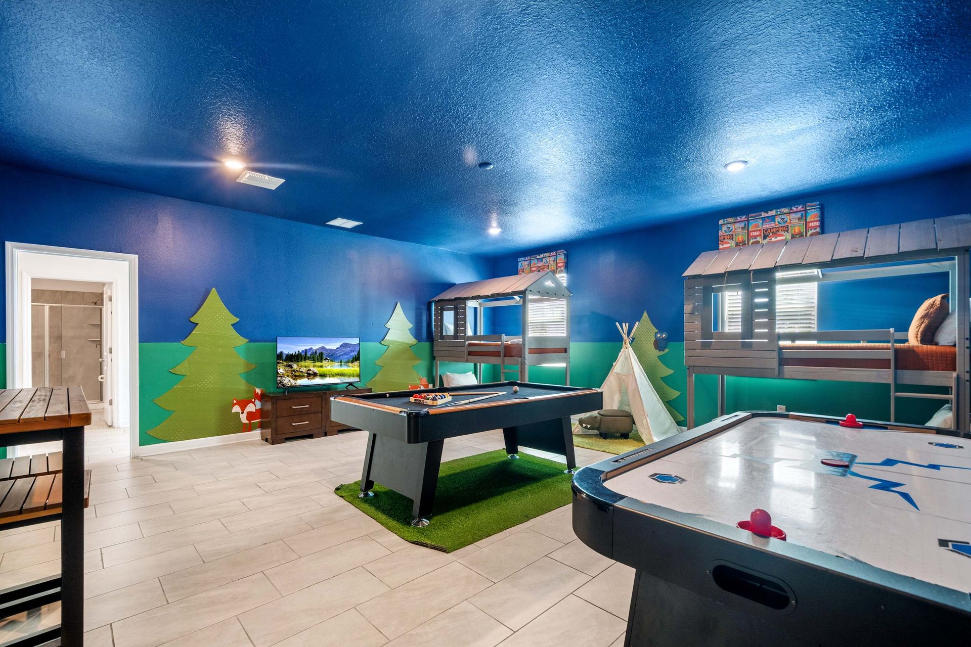 Pool, air hockey, and camping-themed bunks in a huge game room. 