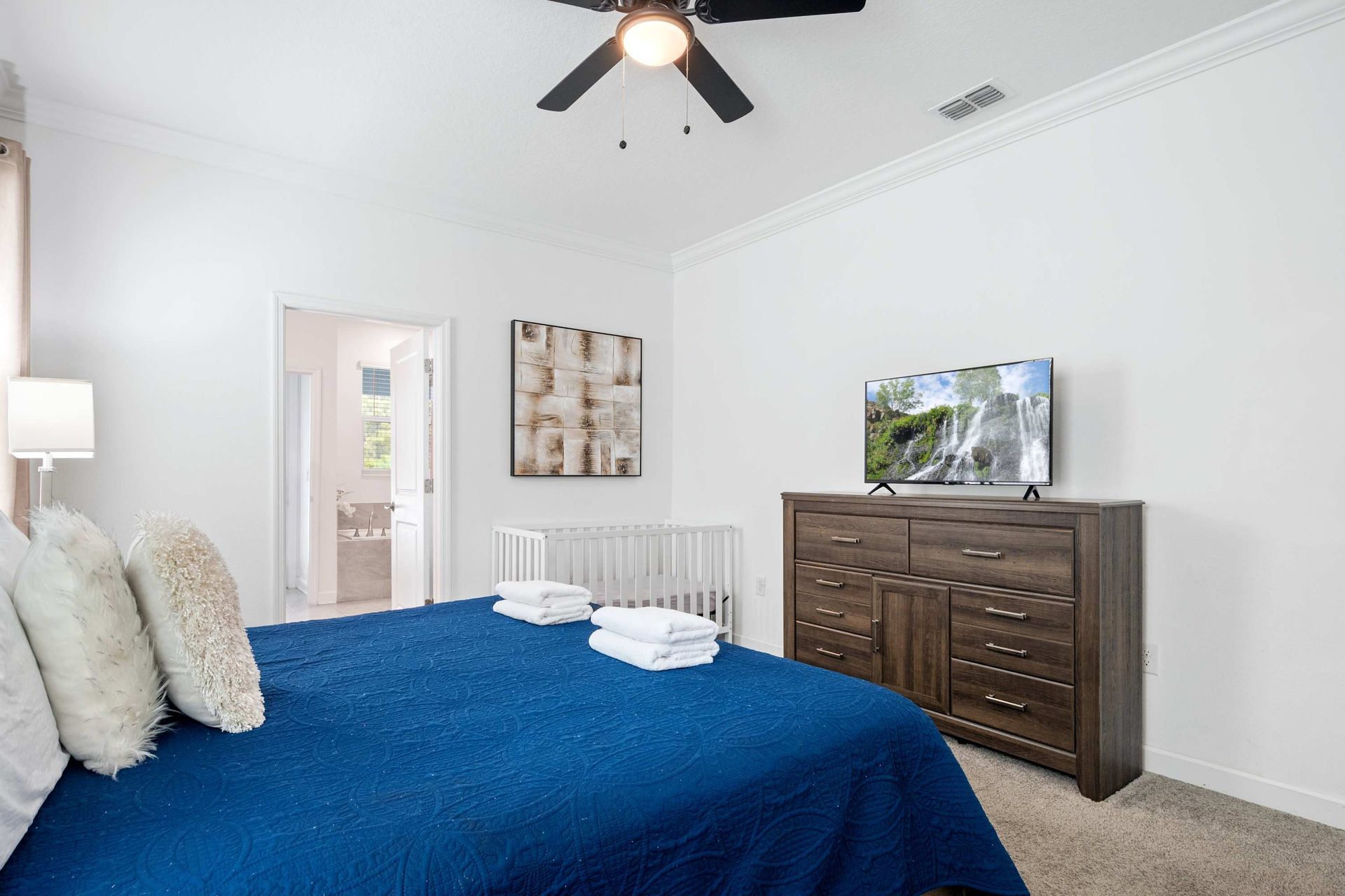 Spacious master with a king bed, TV, and crib for family travel. 