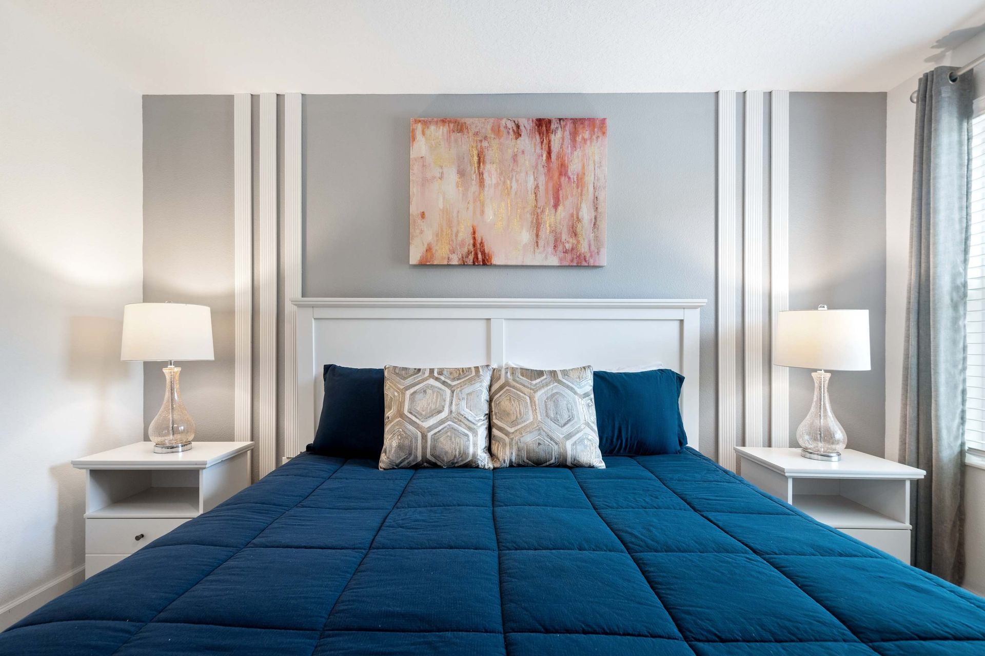 Cozy queen bed and soft lighting for a chic, relaxing retreat.