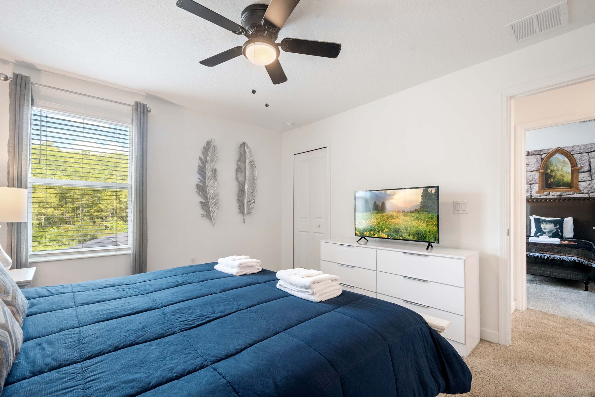 Bright, airy King room with crisp white furniture and a deep blue quilt.