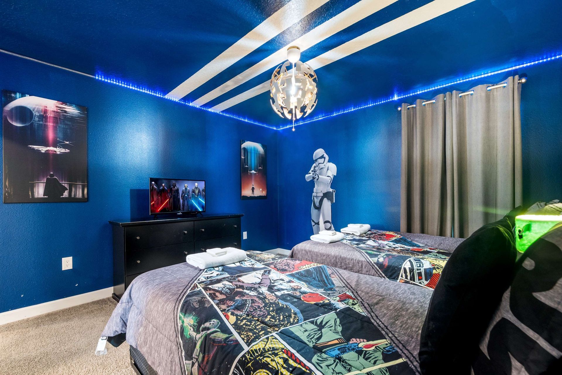 Twin beds in an electric blue STAR WARS room with cool LED lighting.