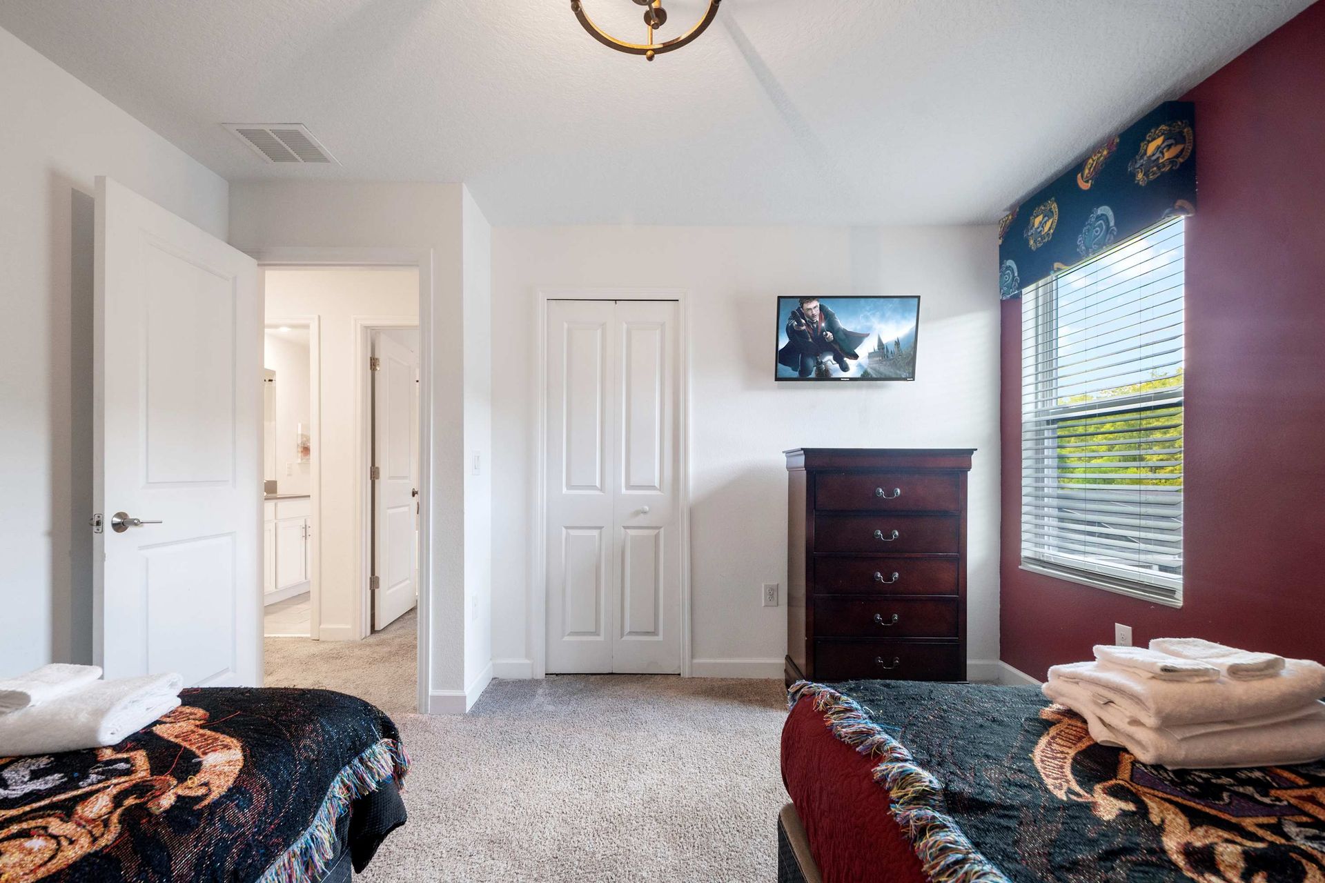 Two twin beds, TV, and en suite bath access in a themed room.