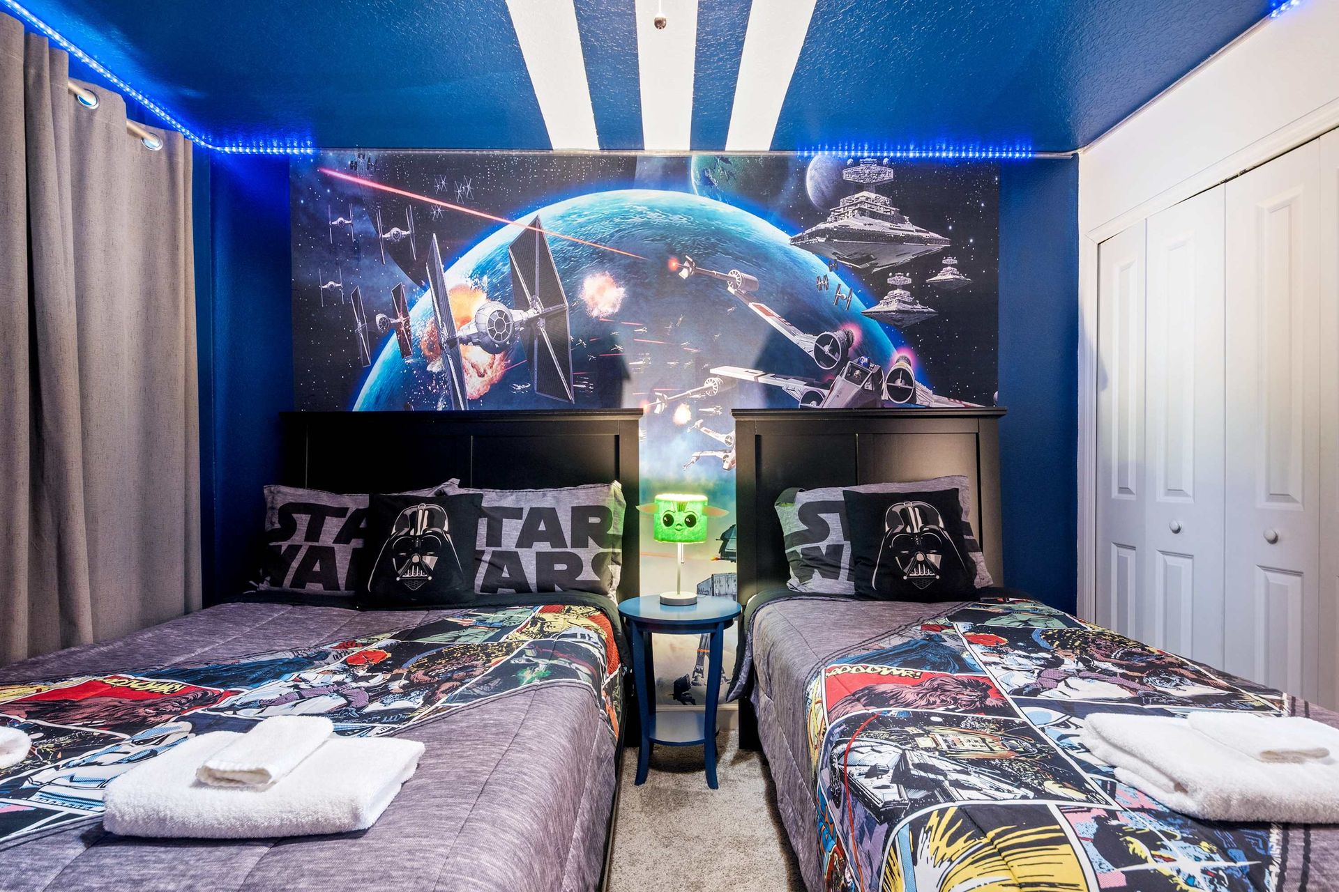 Twin beds and epic sci-fi mural in this STAR WARS themed room.
