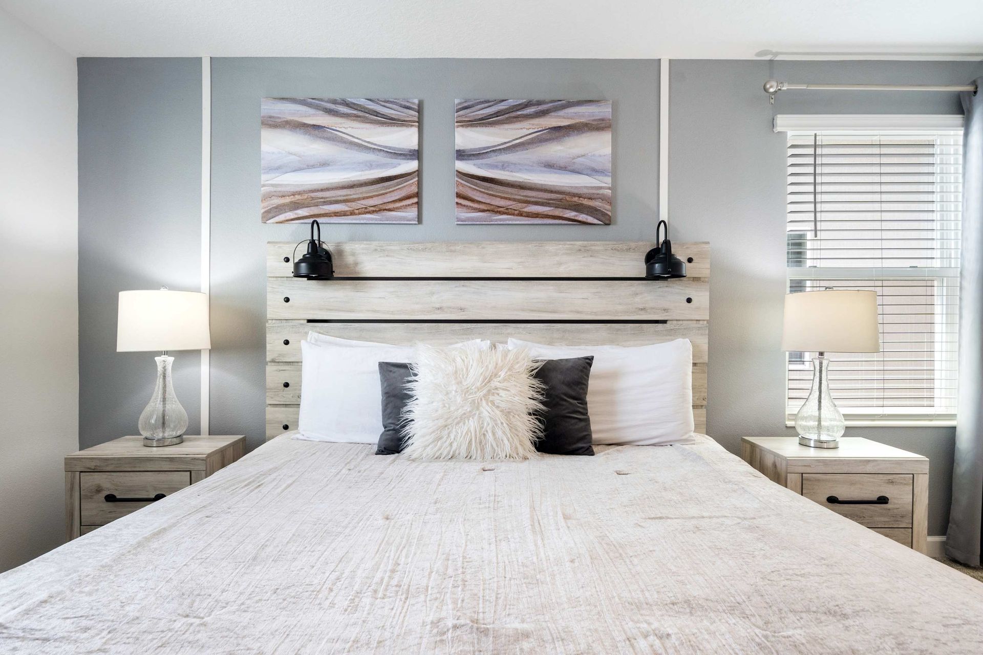 Rustic chic king bed with distressed wood headboard and stylish art.