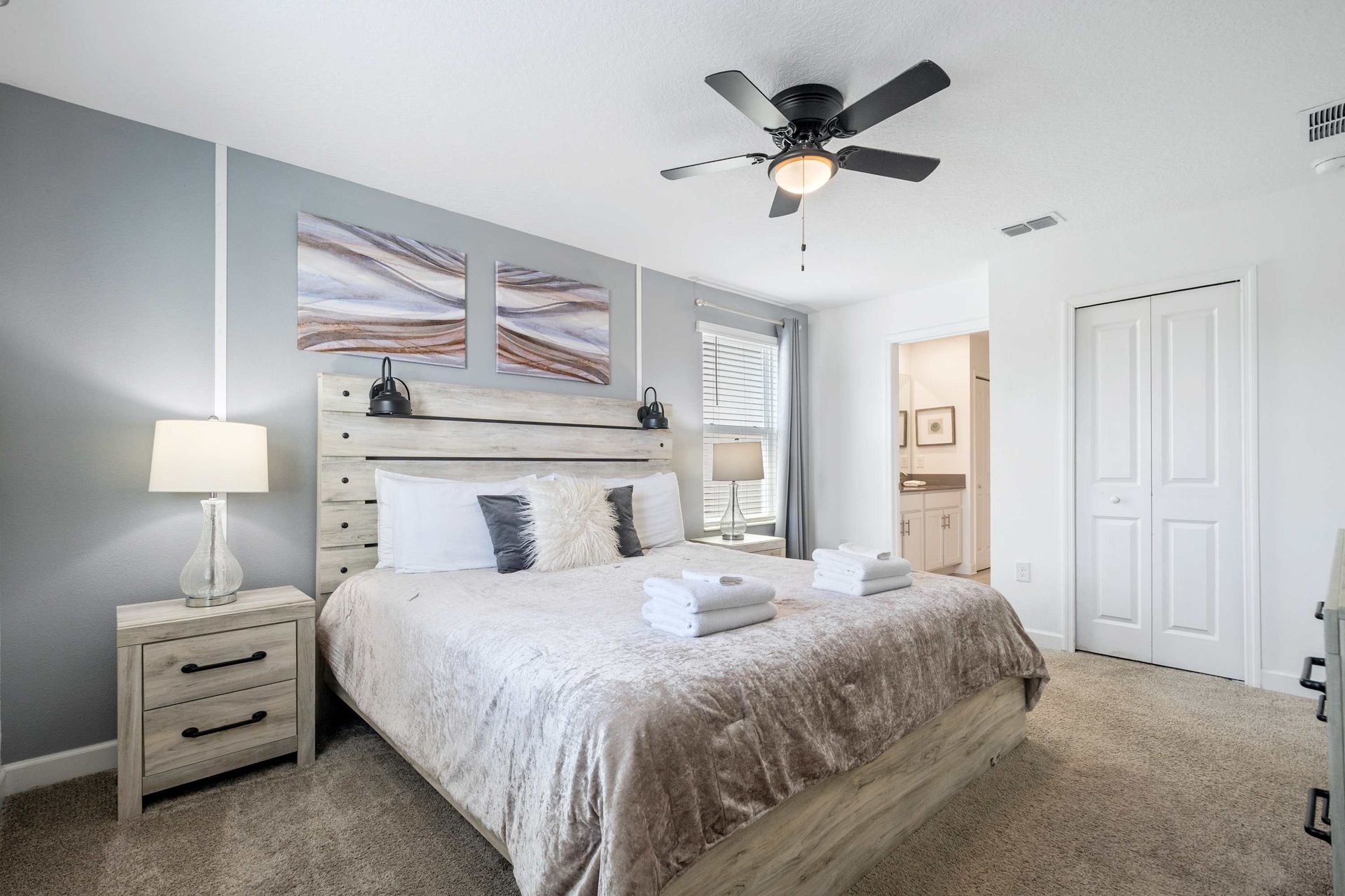 Spacious King suite with rustic-chic headboard and modern art.
