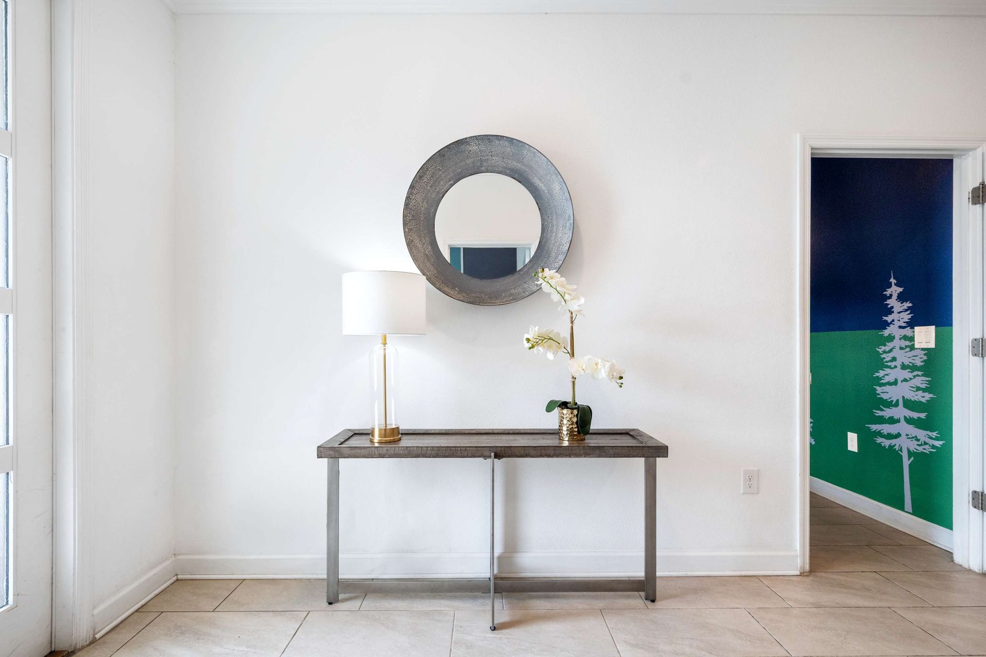 Chic console and mirror contrast with the boldly painted themed room.
