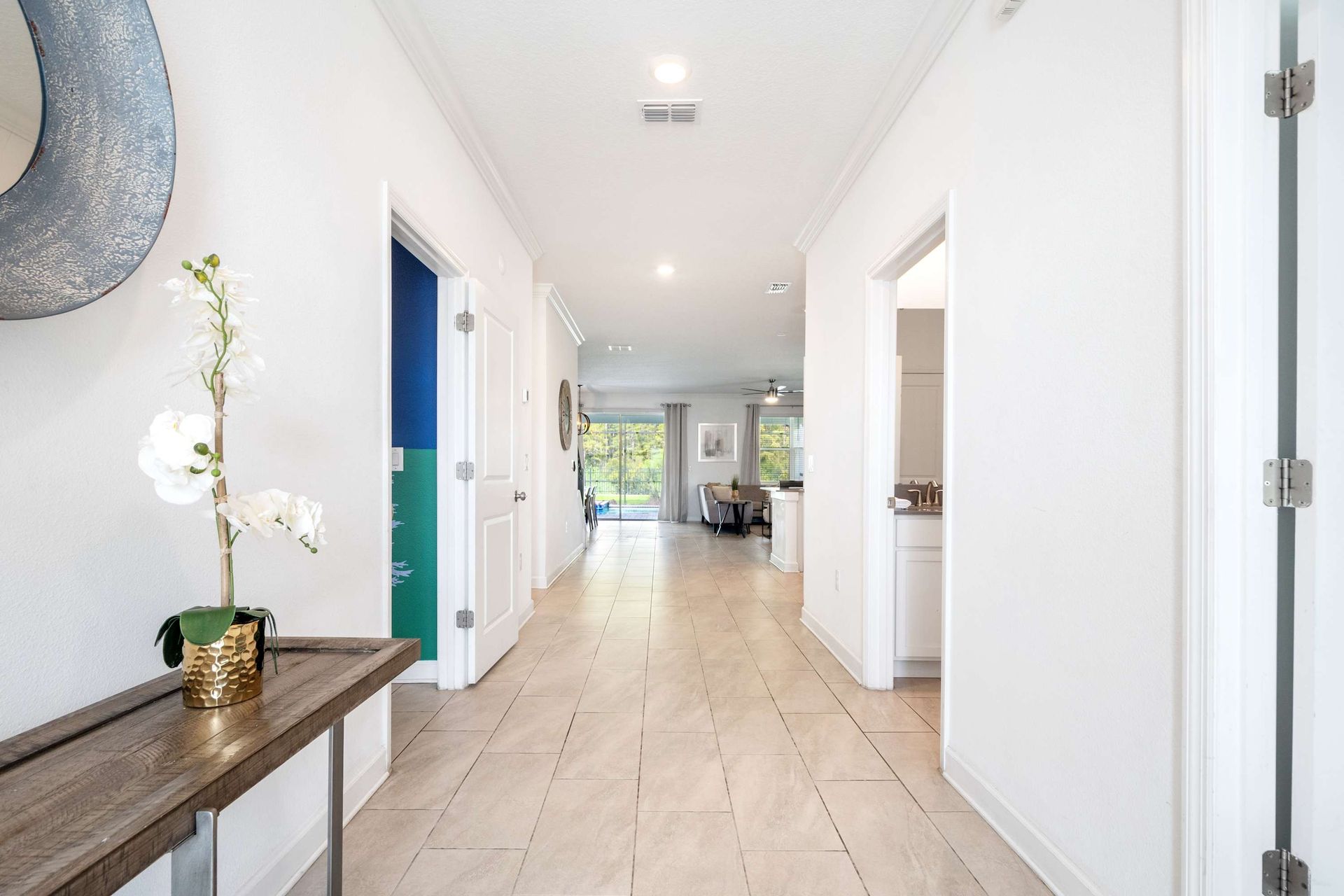 Long, bright hallway with elegant console leading to the open living space.