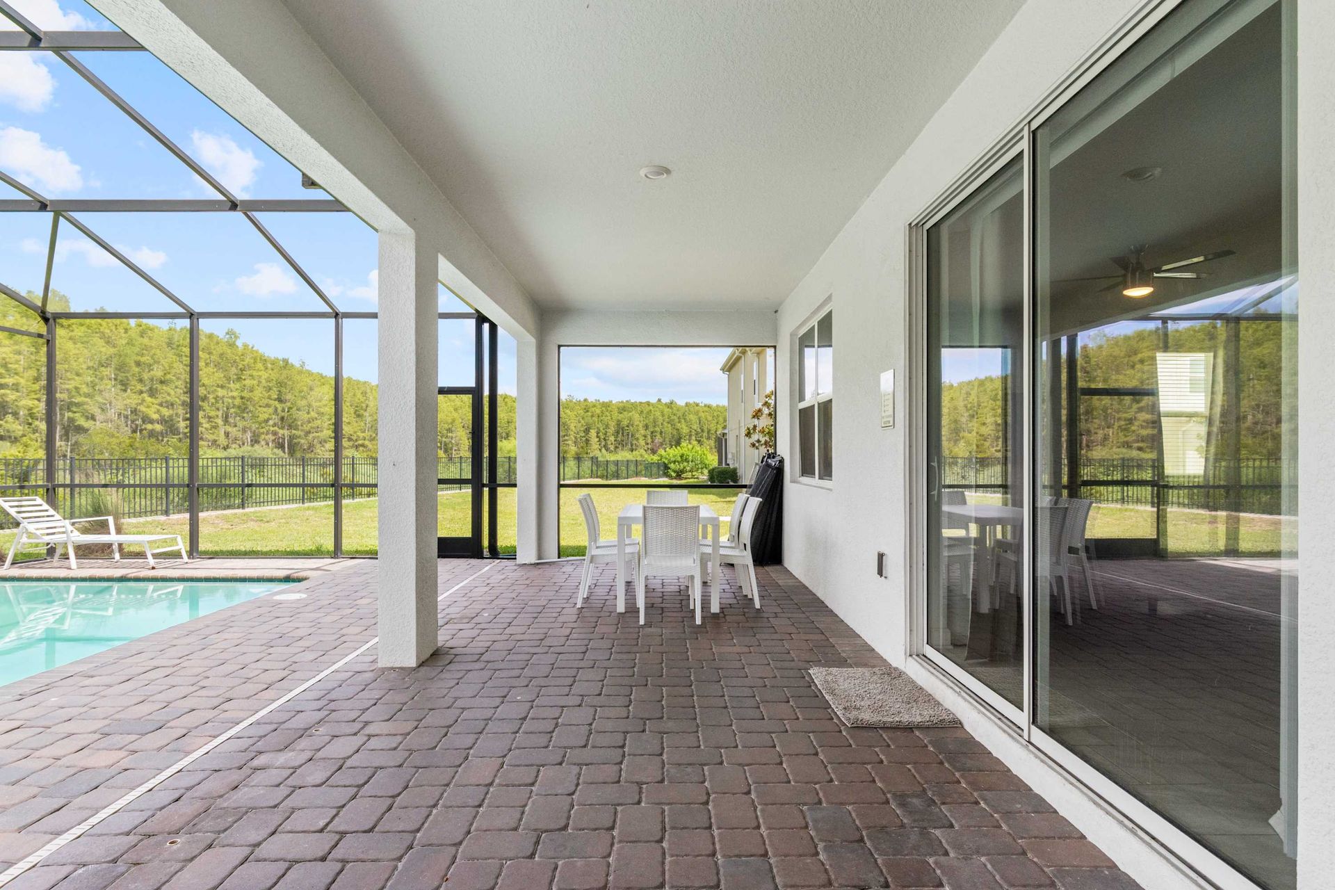 Spacious covered patio with a beautiful pool and conservation view.