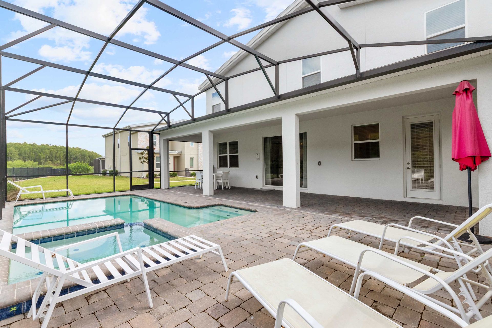 Sparkling private pool and spa with shaded patio and sun loungers.