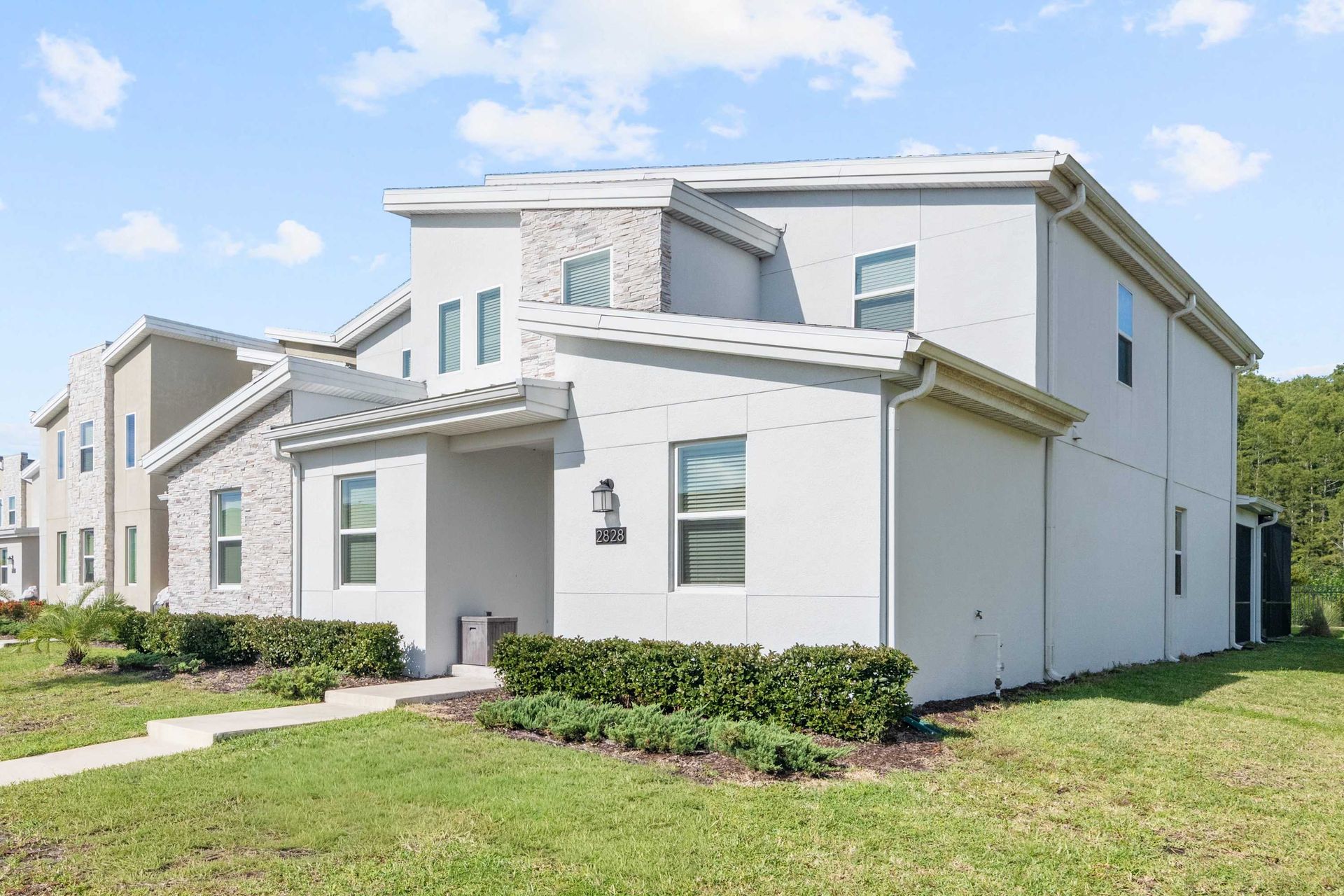 Sleek, modern two-story townhome with clean lines and stucco facade.