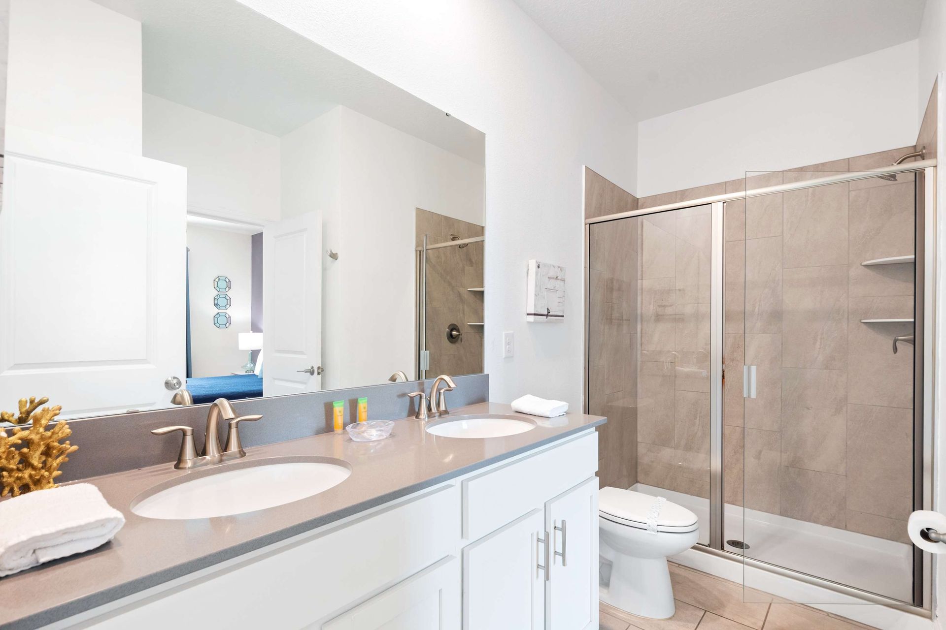 Sleek master bath with dual sinks and a large glass walk-in shower.