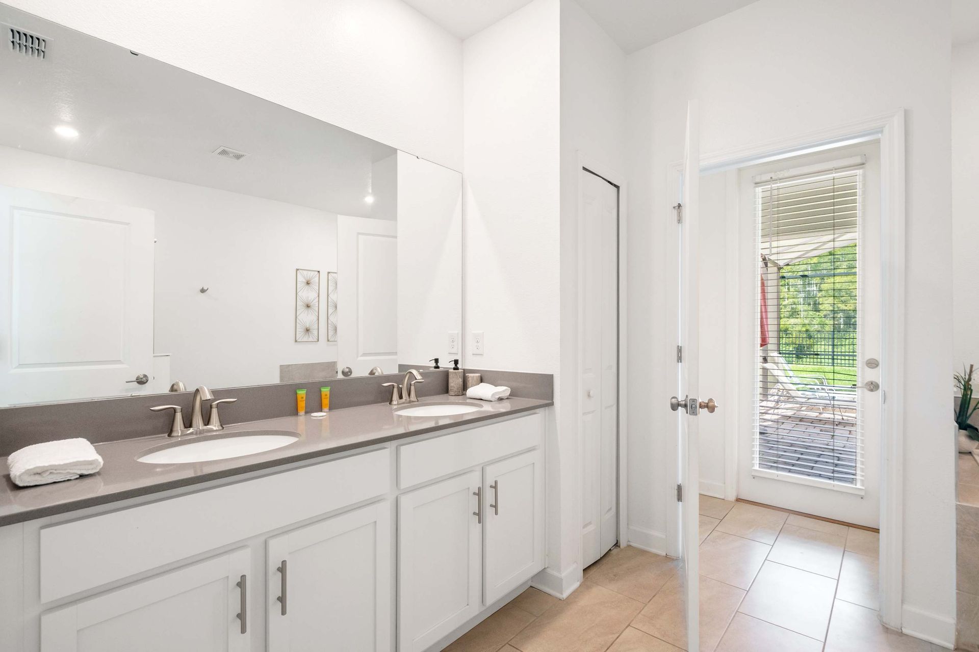 Dual vanity, sleek counters, and direct access to the patio/pool area. 