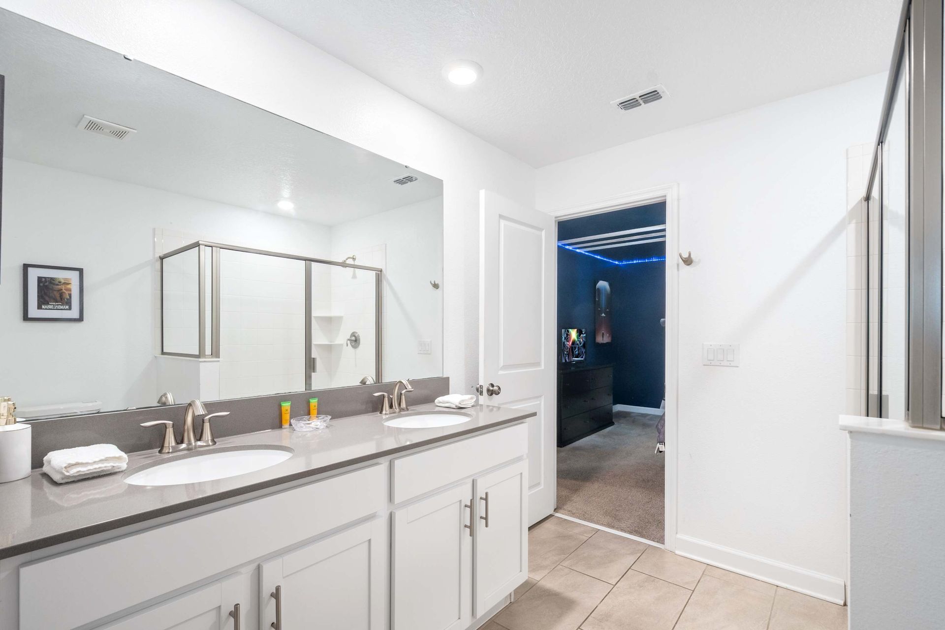 Master bath with dual vanity, quartz counters, and glass walk-in shower.