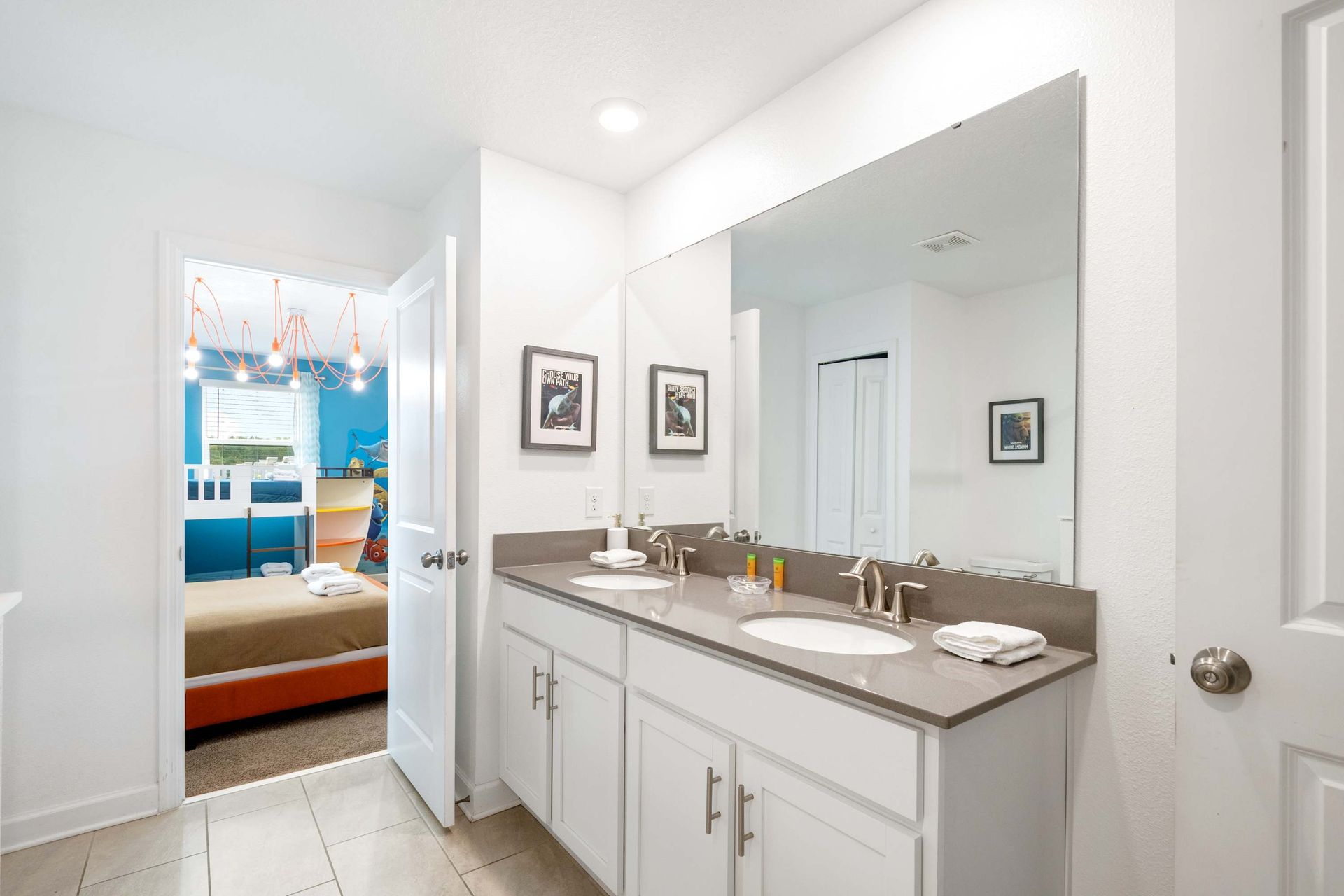 Dual vanity master bath opens to a vibrant, ocean-themed bedroom. 