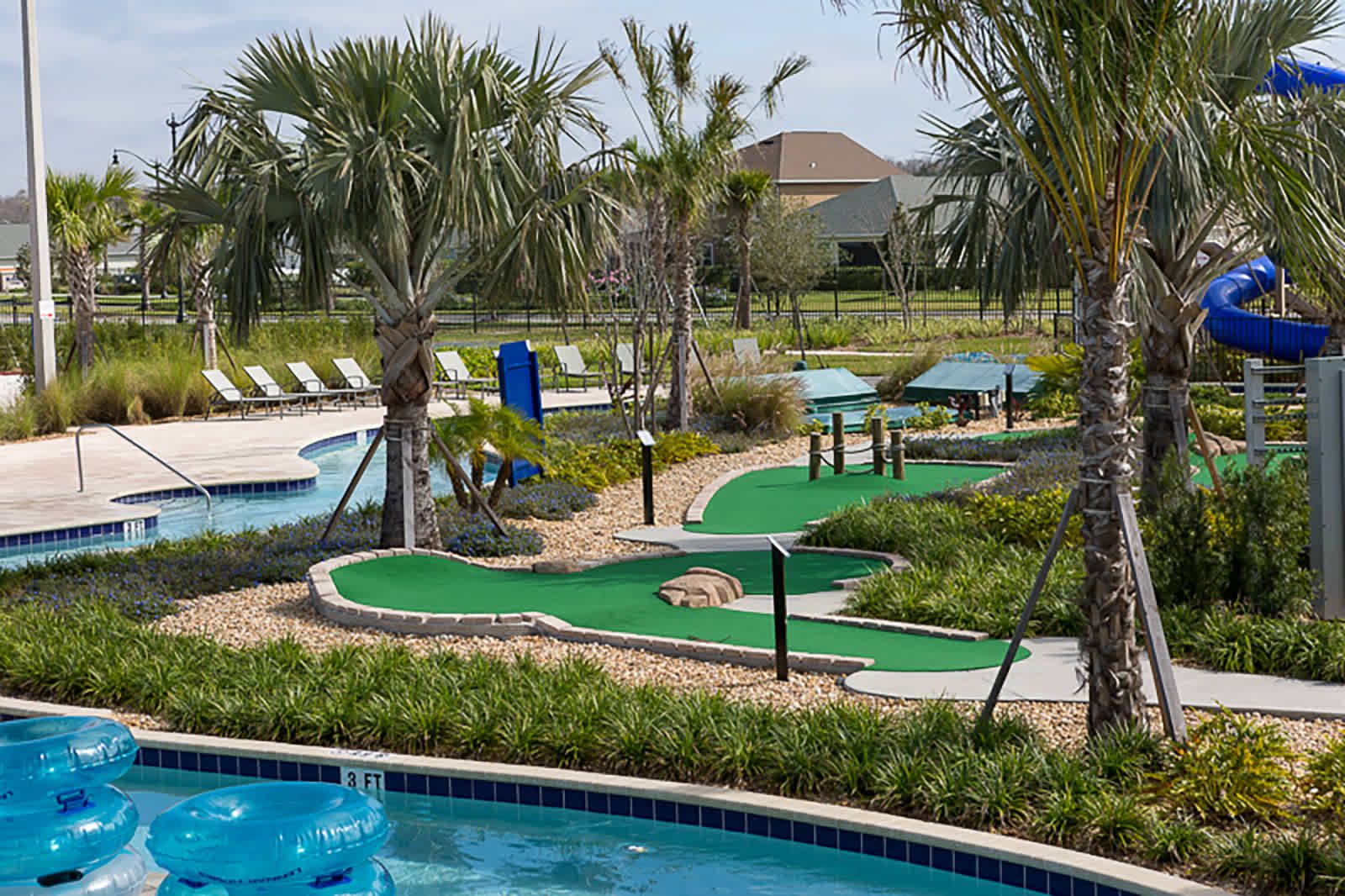 Lazy river and mini golf surrounded by sunny palm trees. 