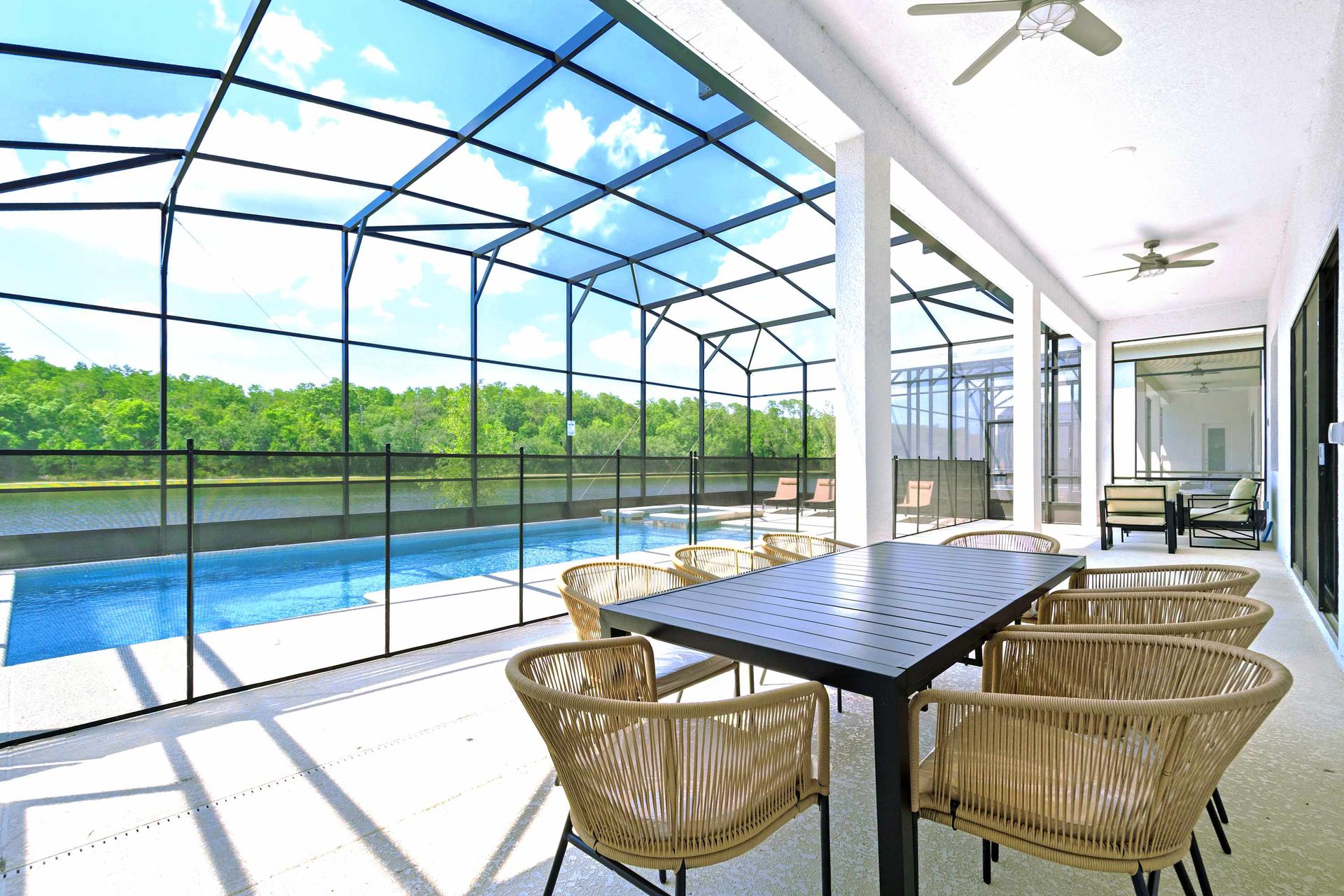 Dining al fresco next to a screened pool with a serene lake view.