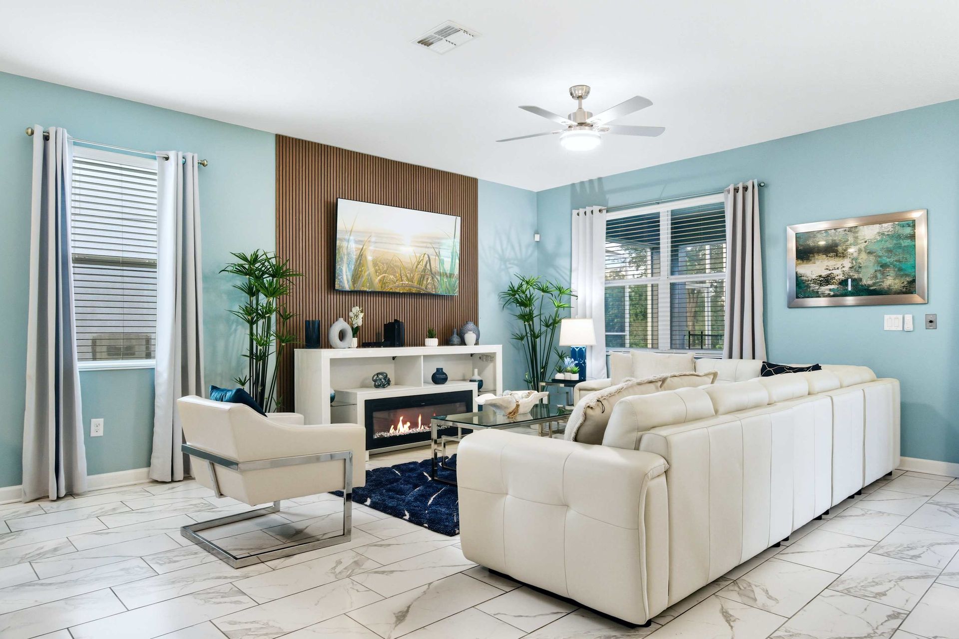 Coastal chic: blue walls, wood-slat media wall, and modern fireplace.