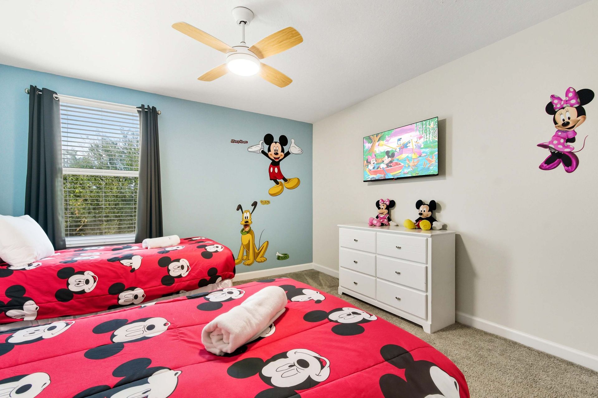 Mickey Mouse twin room with bright decor and TV.