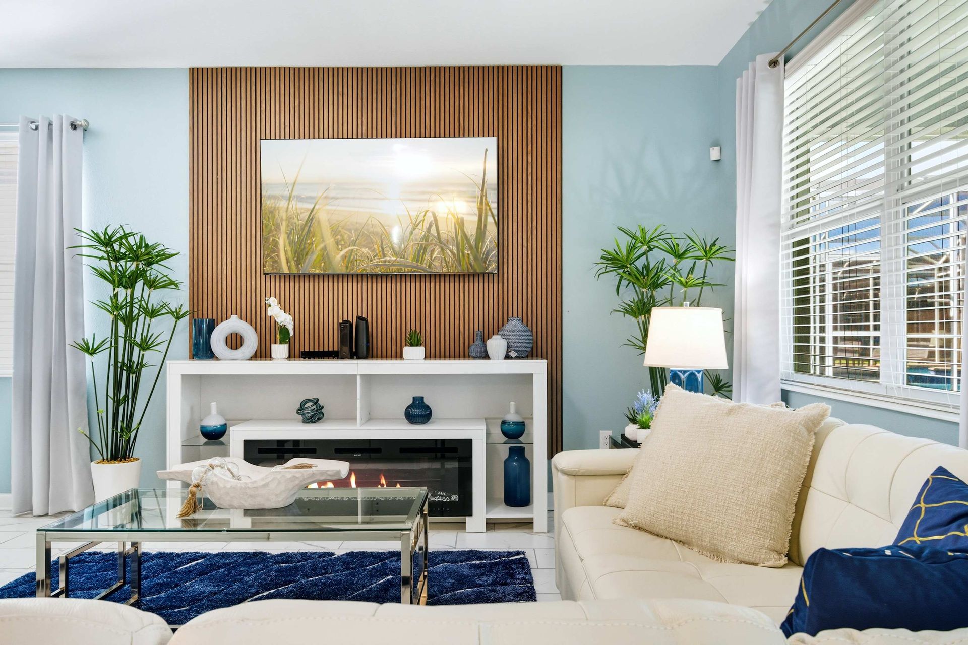 Coastal chic: wood slat media wall, electric fireplace, and blue accents.