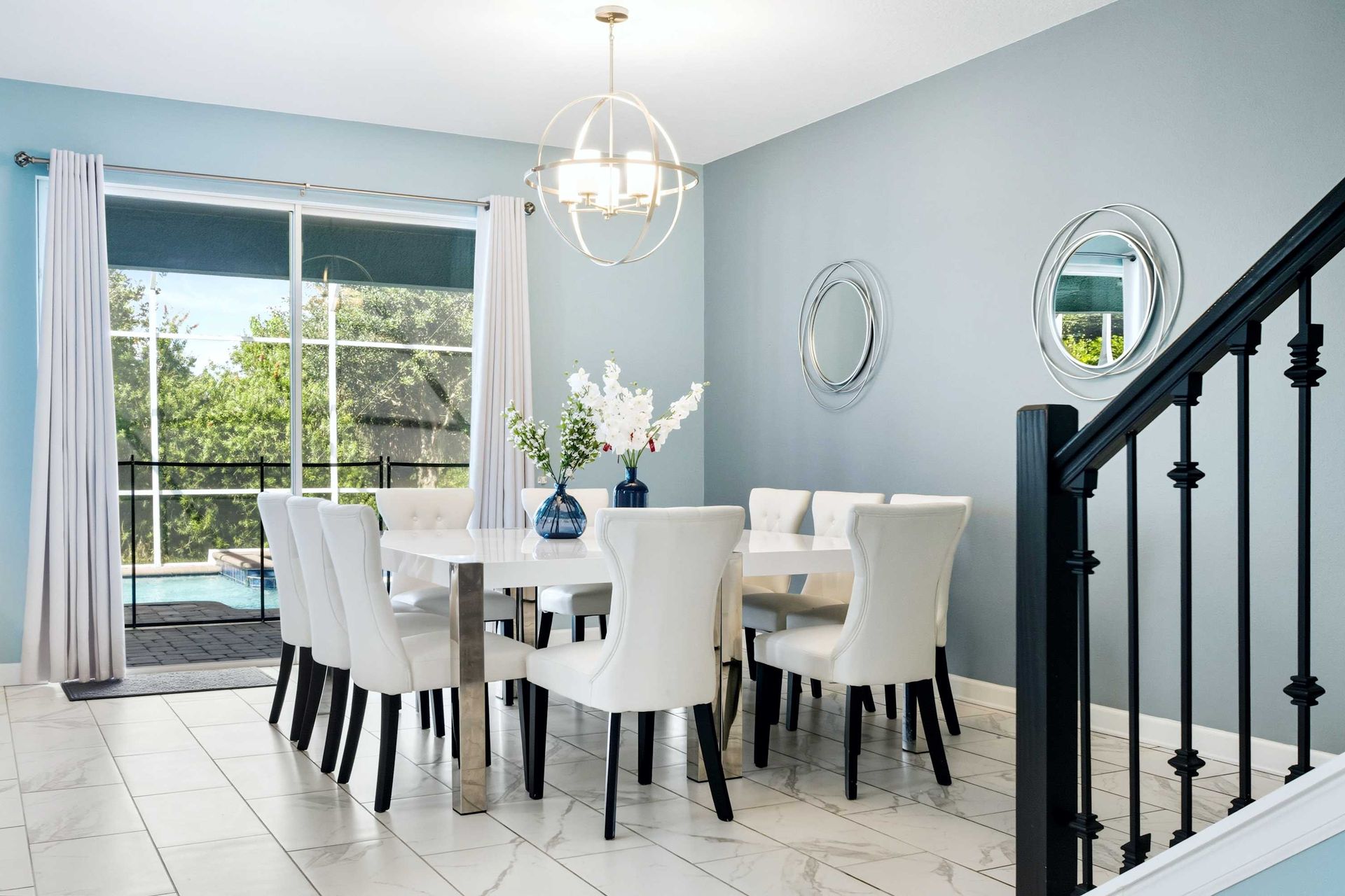 Chic dining for eight with pool views and serene blue walls.