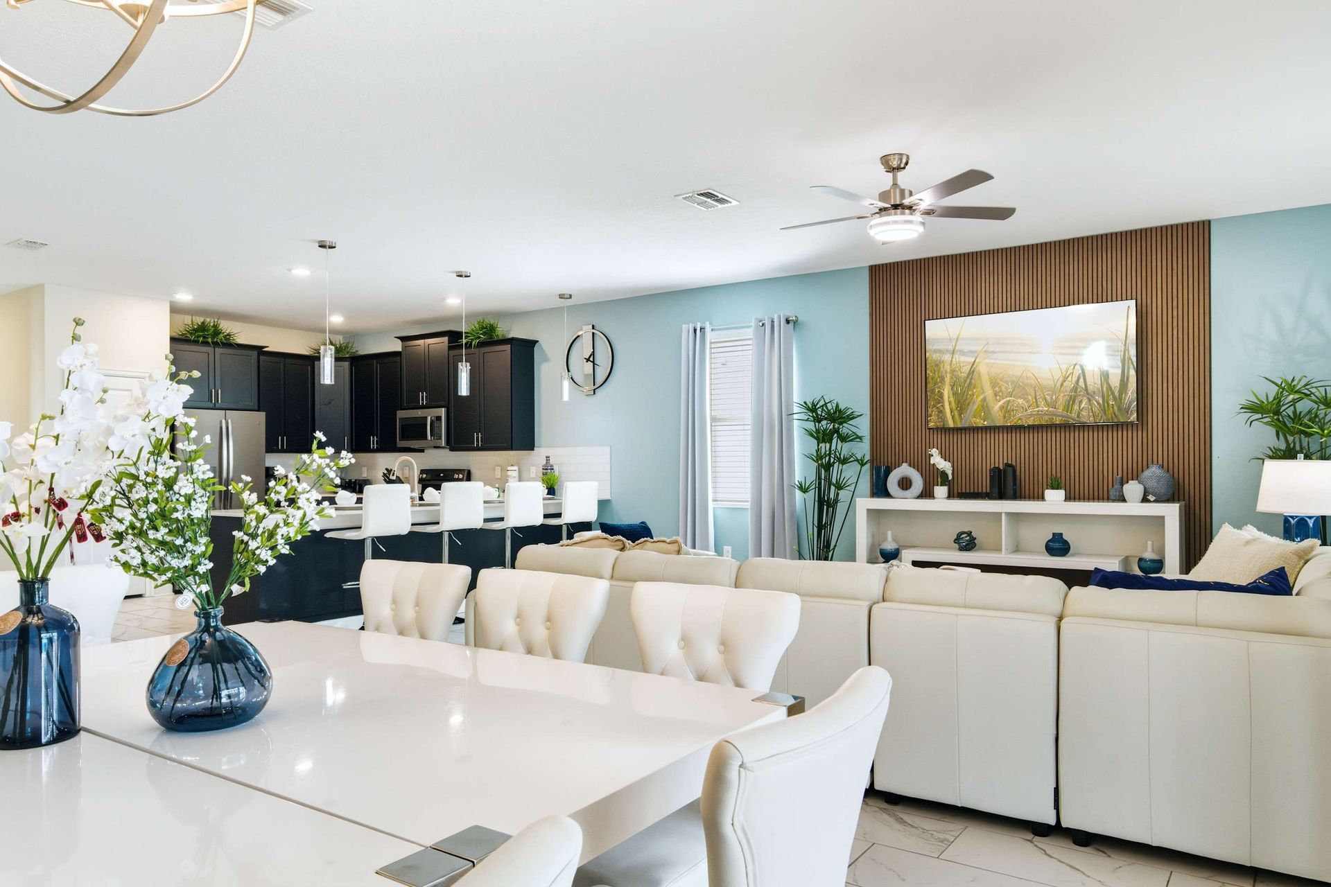 Open flow: elegant dining, spacious lounge, and dark modern kitchen.