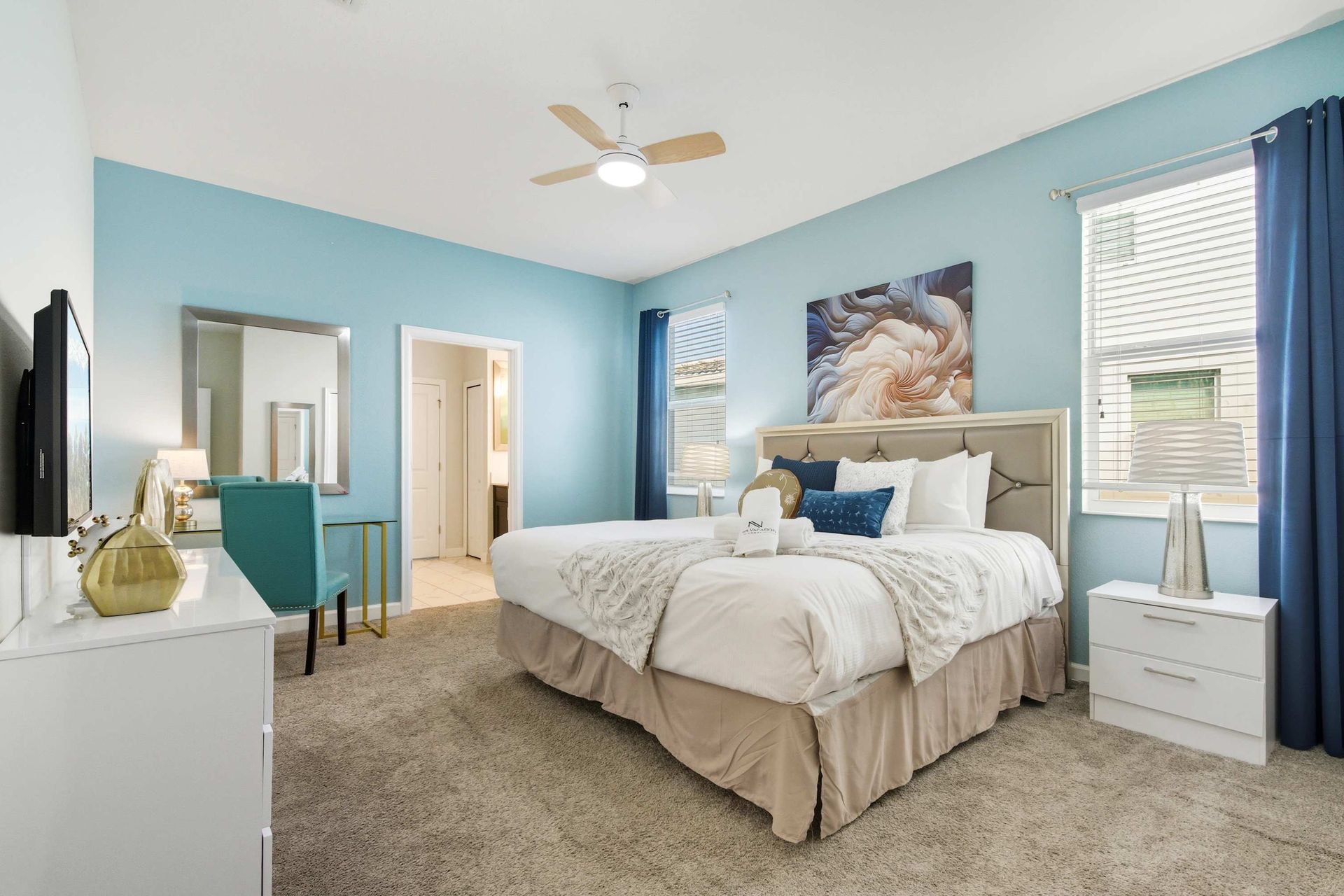 Stylish blue bedroom with comfy Queen bed and modern art.