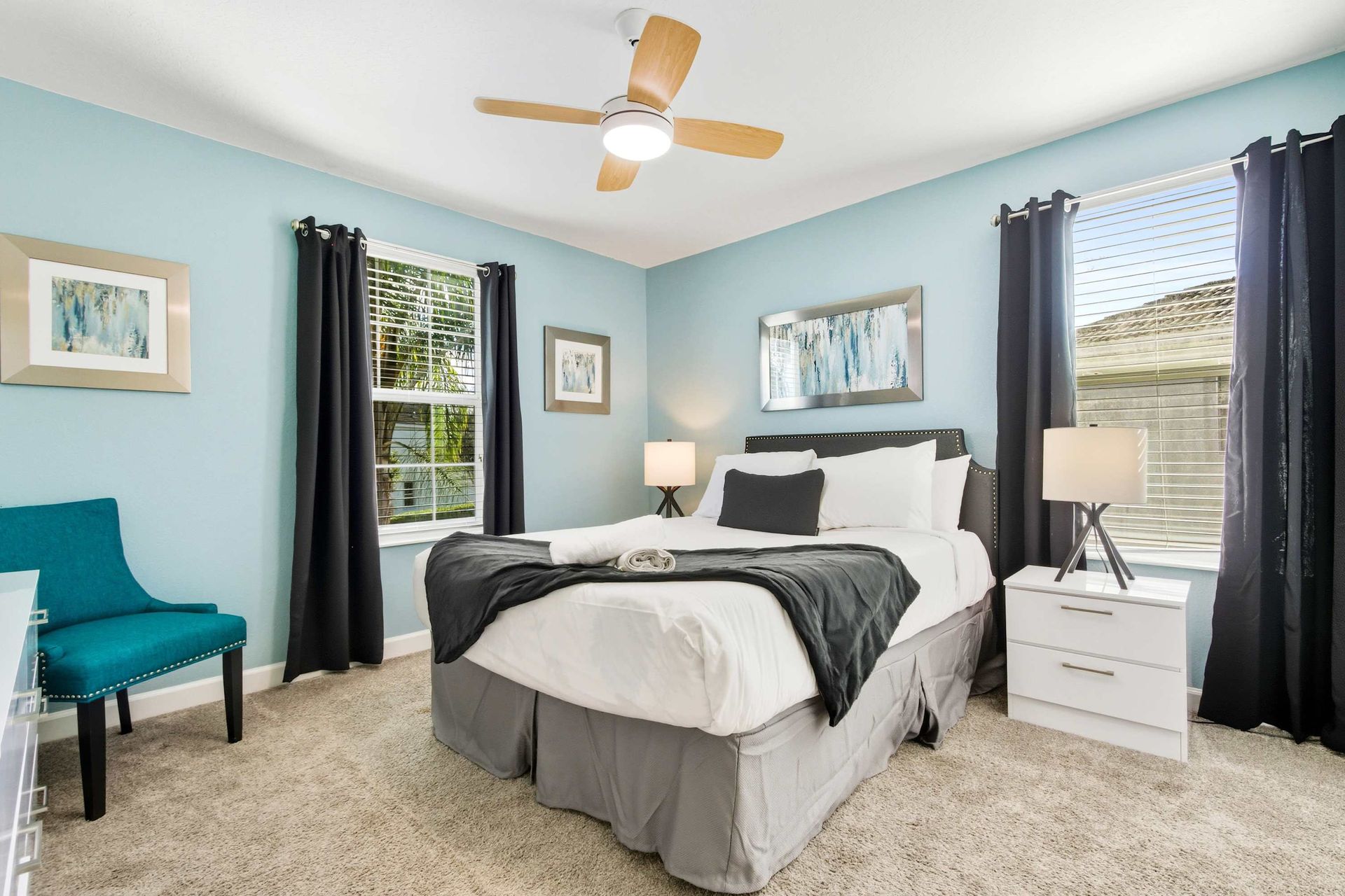 Serene blue walls, plush Queen bed, and elegant dark accents.
