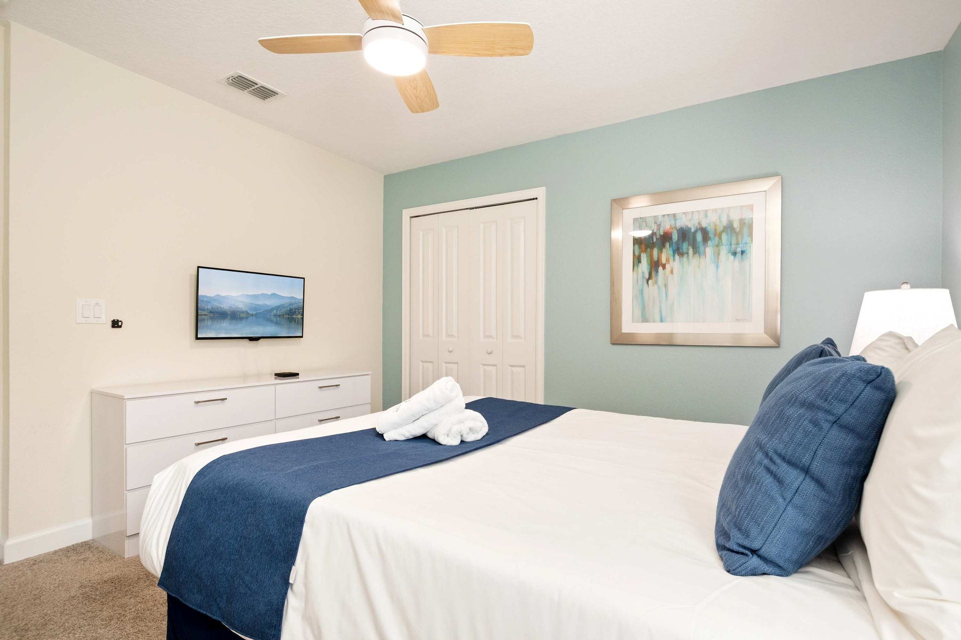 Bright, cozy King room with cooling blue tones.