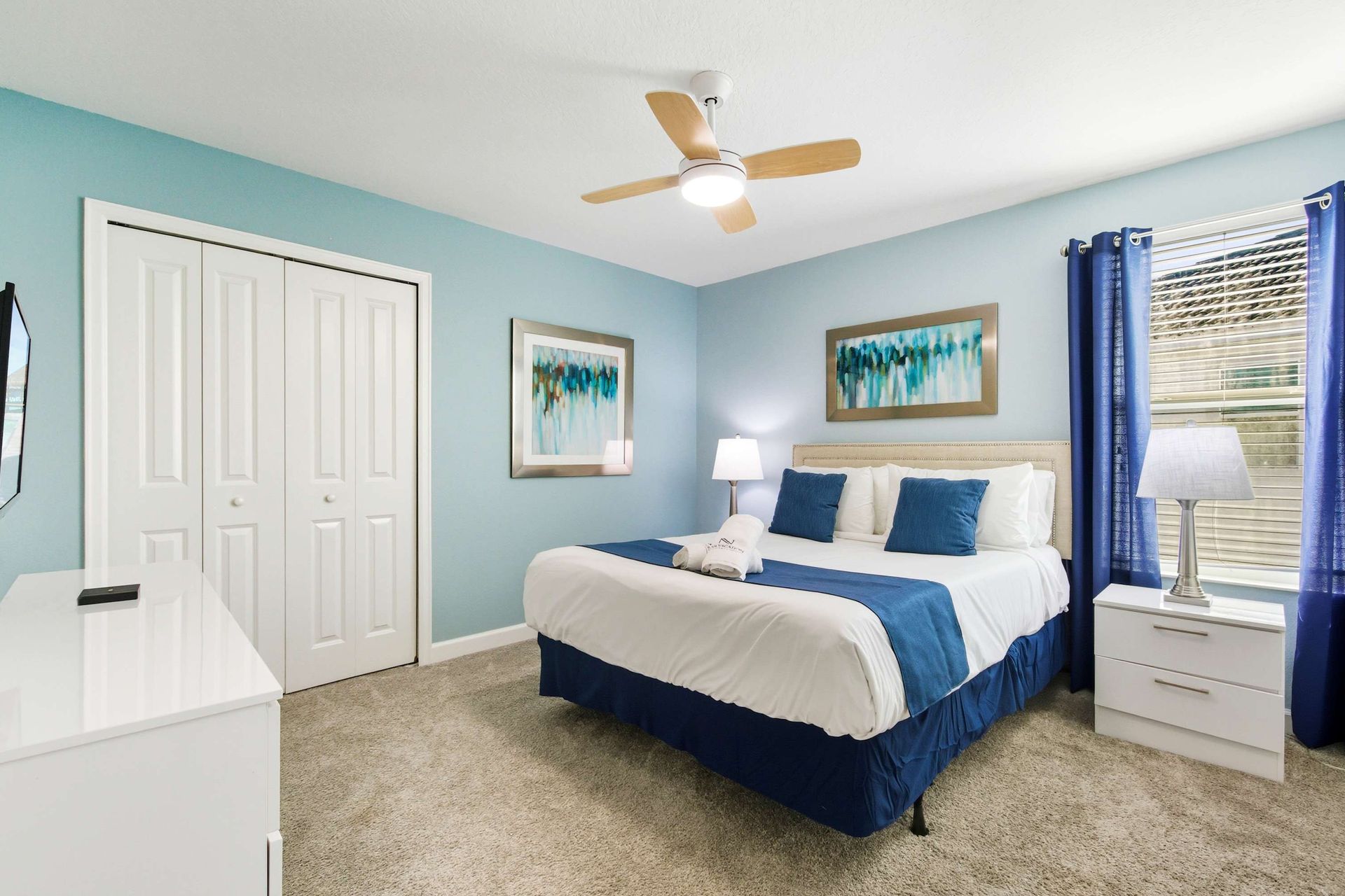 Coastal-inspired King bed with elegant art and modern nightstands.