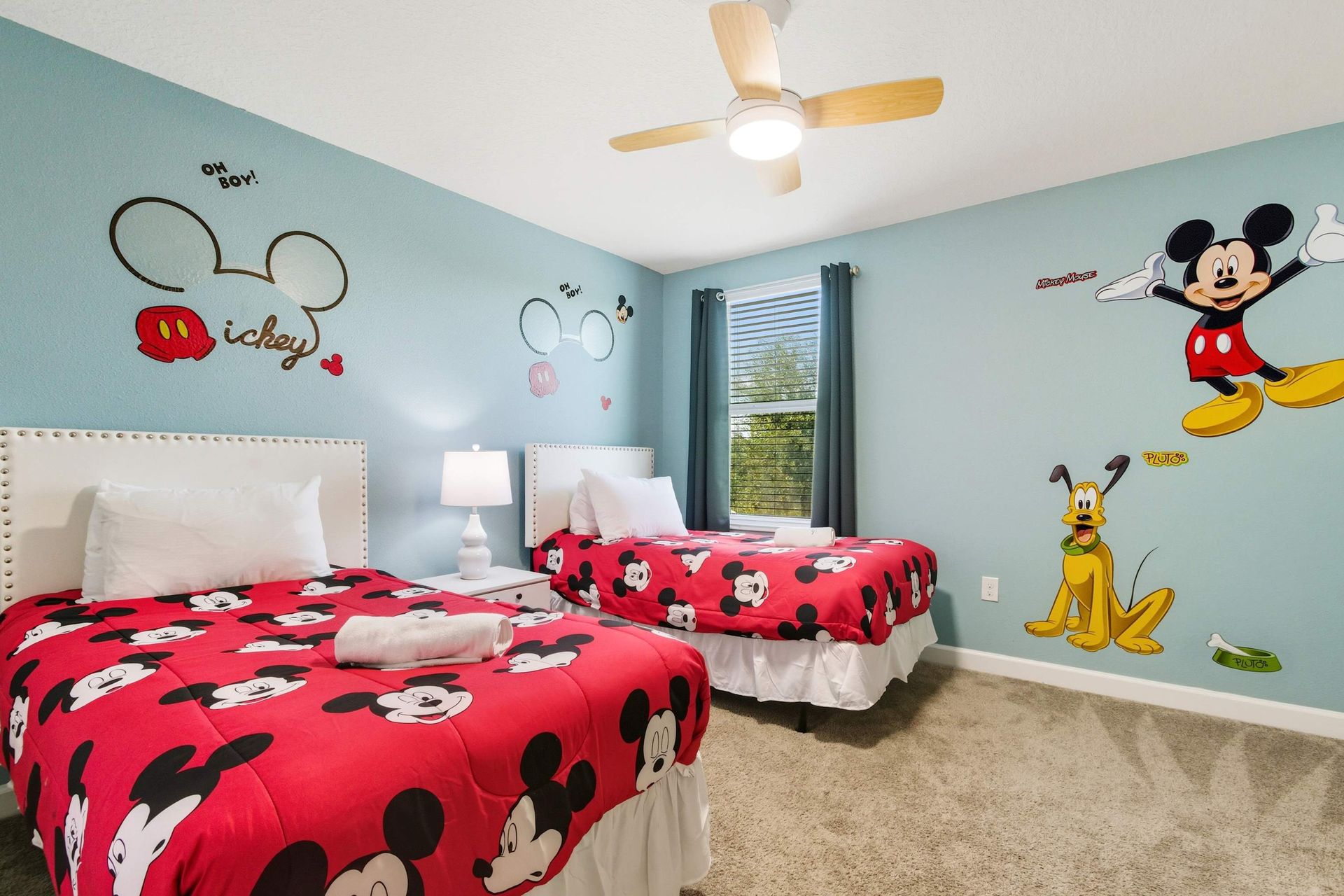 Twin beds in a vibrant Mickey Mouse-themed room.