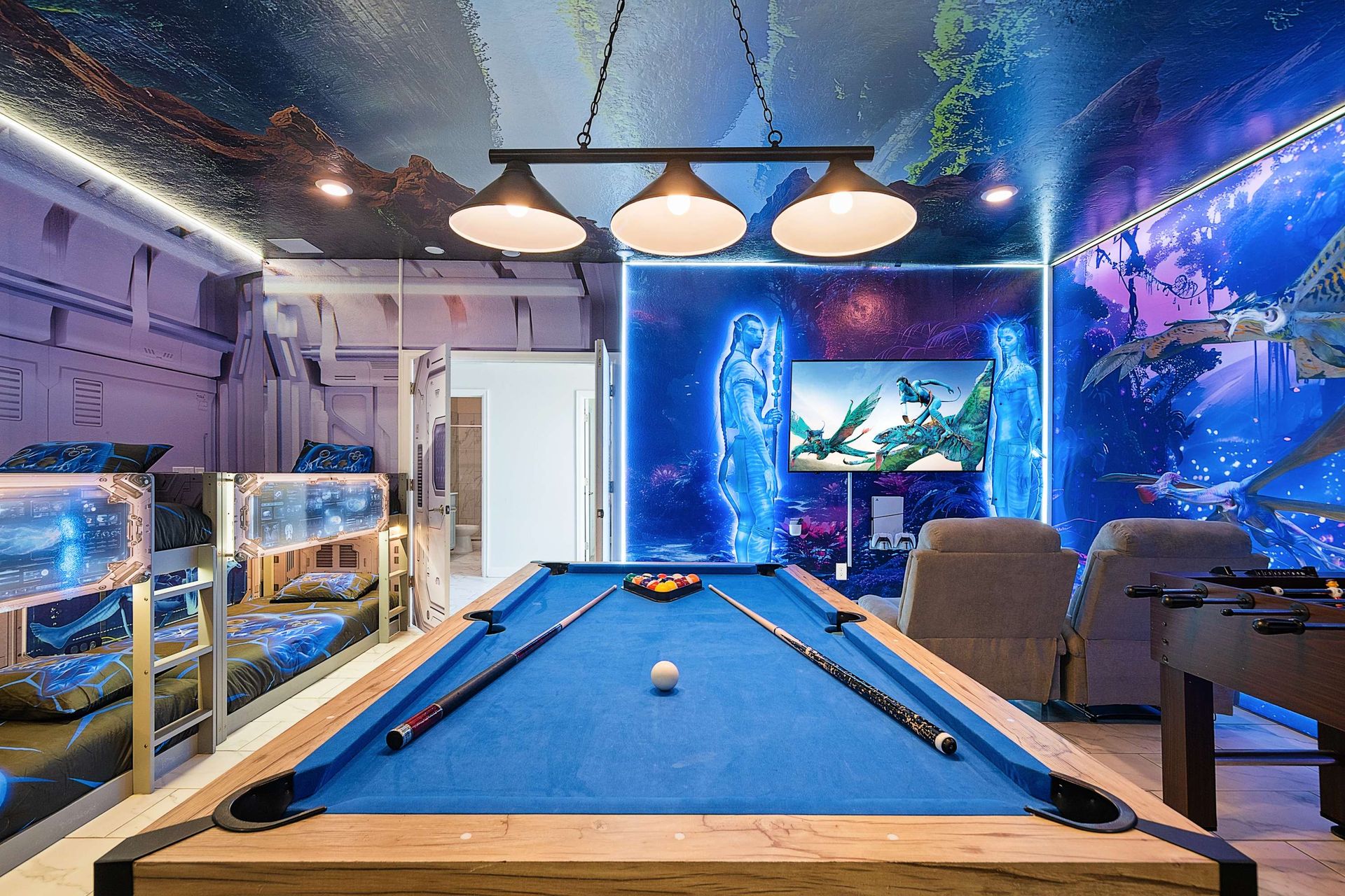 Challenge friends on the blue-felt pool table backed by breathtaking Avatar wall art and ambient lighting — perfect for fun photos and family tournaments.