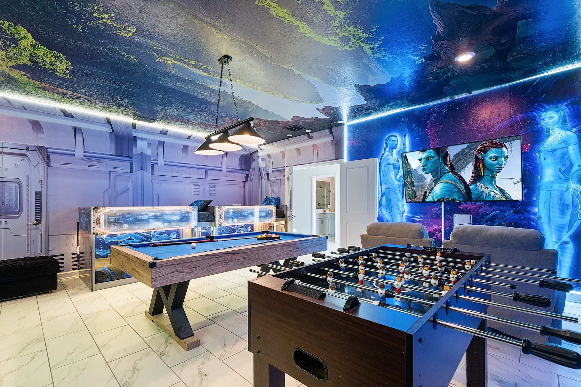 Spacious open game area with pool, foosball, and lounge seating under stunning ceiling art — designed for nonstop family fun.