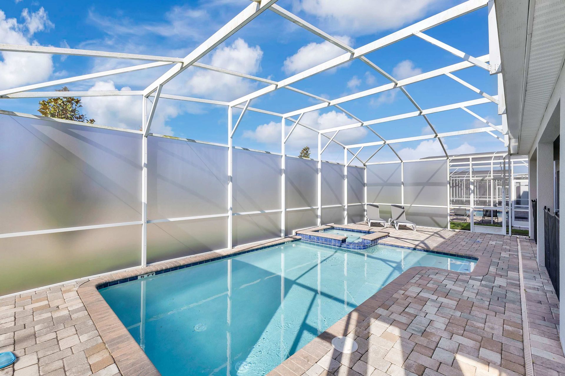 A modern resort playground featuring a unique, white climbing structure and soft flooring.