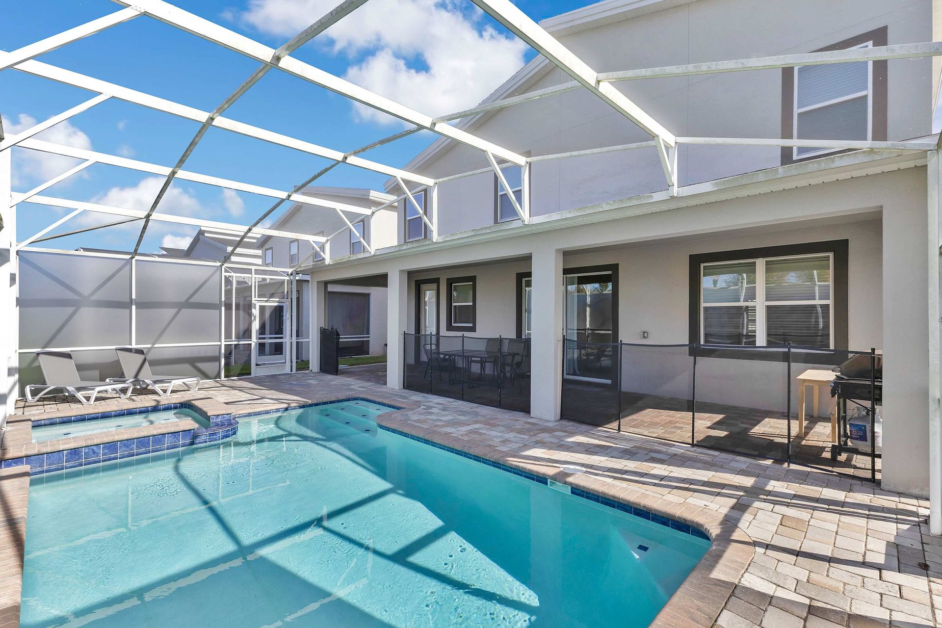 Large, circular resort swimming pool surrounded by palm trees and red-roofed cabanas.