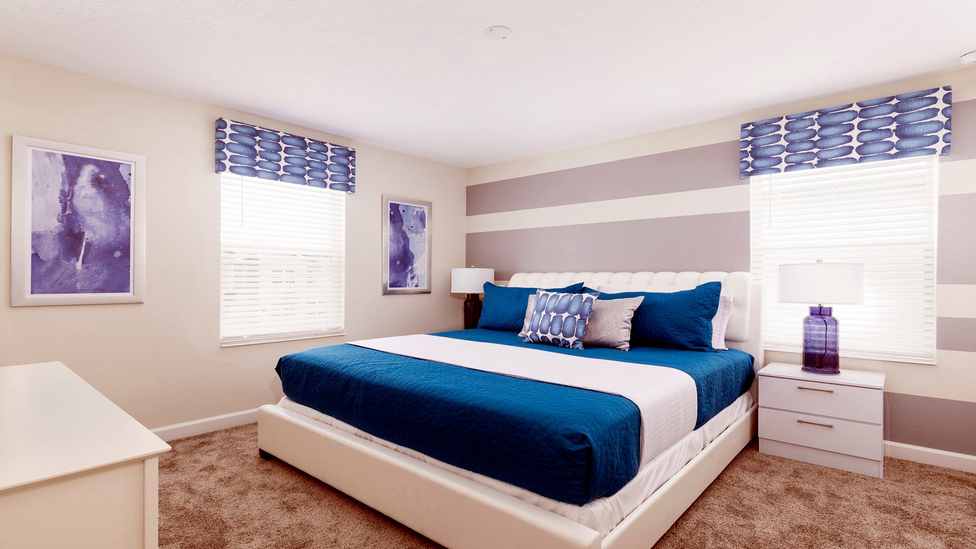 Elegant bedroom with bold blue accents, modern decor, and natural light