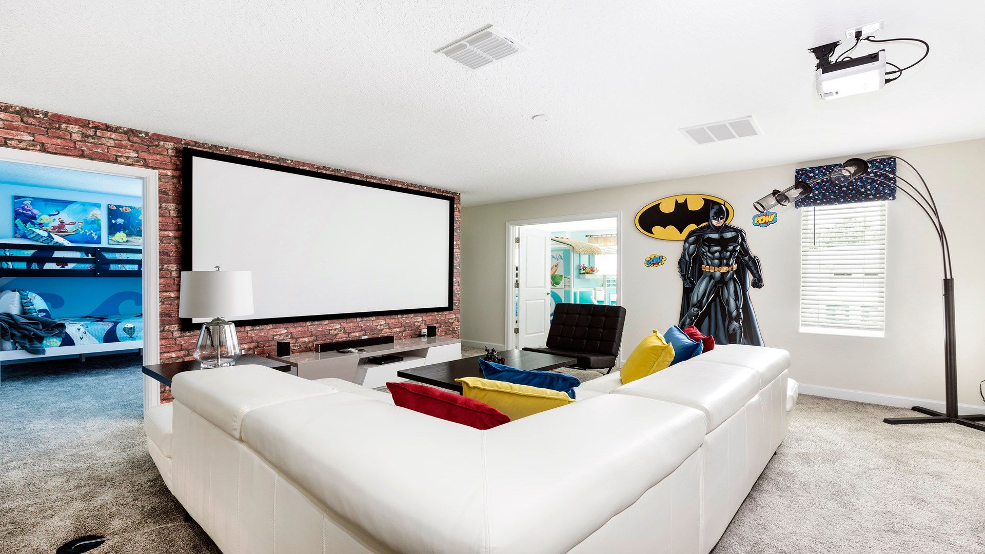 Hero-themed theater room with projector, cozy seating, and fun decor