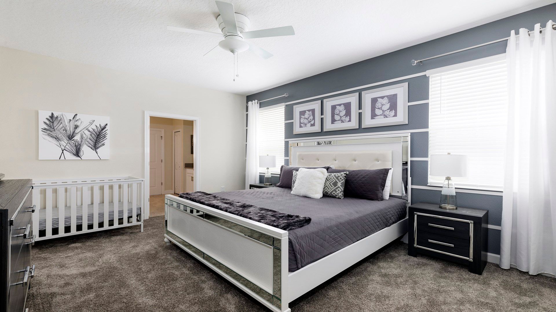 Modern bedroom with elegant decor, cozy bedding, and a baby-friendly crib